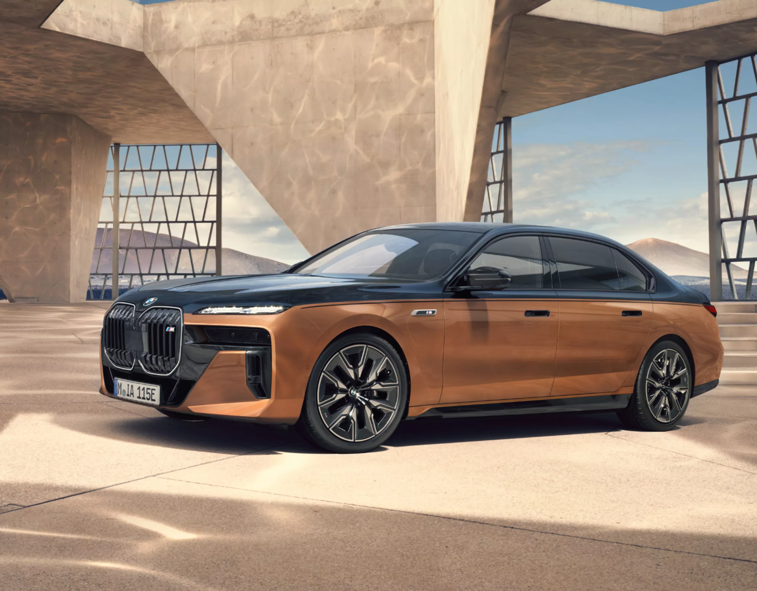 BMW i7 M70 xDrive Berline en teinte Individual Two-Tone dans une construction moderne avec panorama sur les montagnes