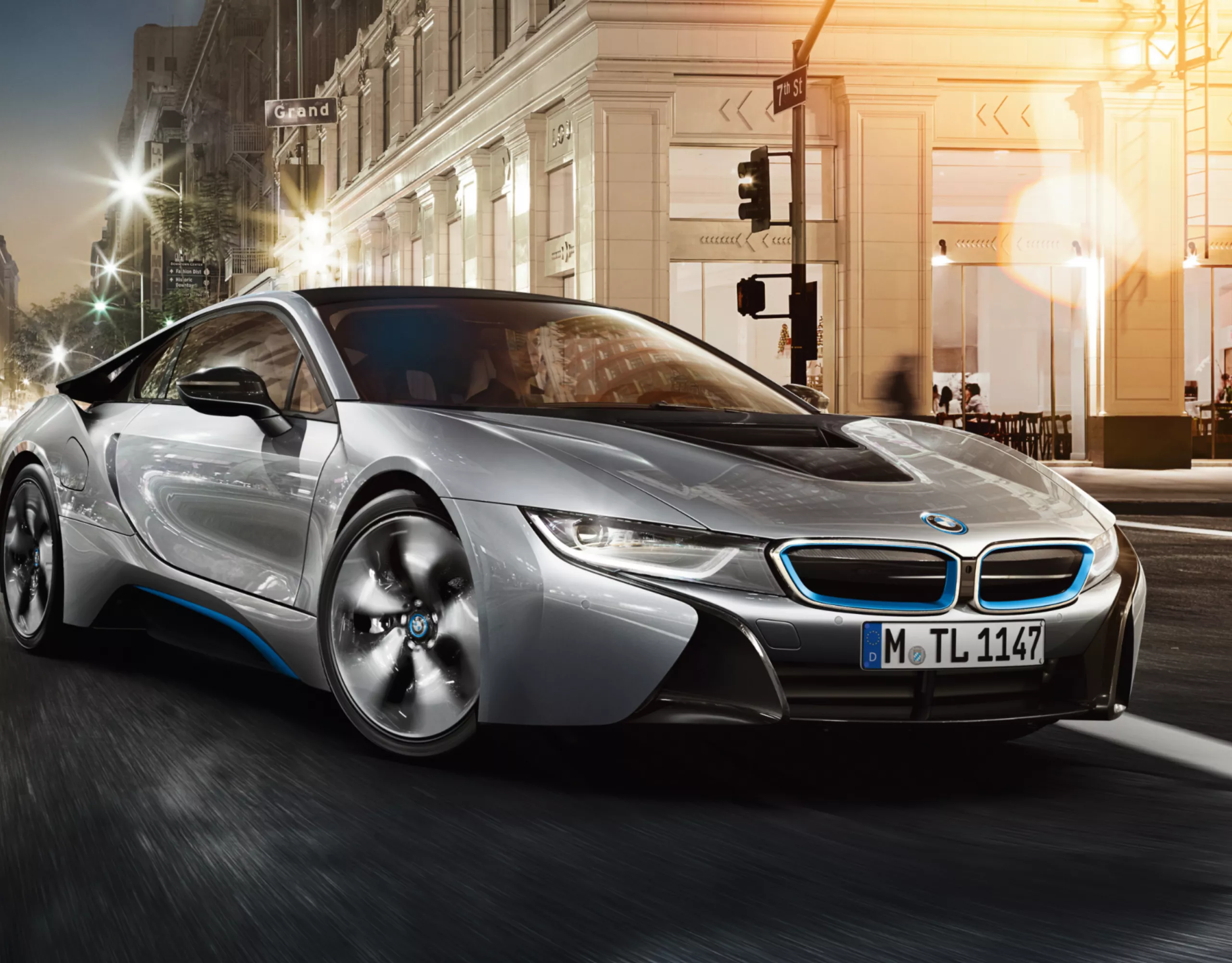 BMW i8 hybride rechargeable argentée garée devant un grand hôtel dans une grande ville