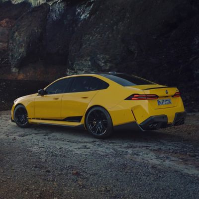BMW M4 with BMW M Performance Motorsport decals by a river with mountains in the background