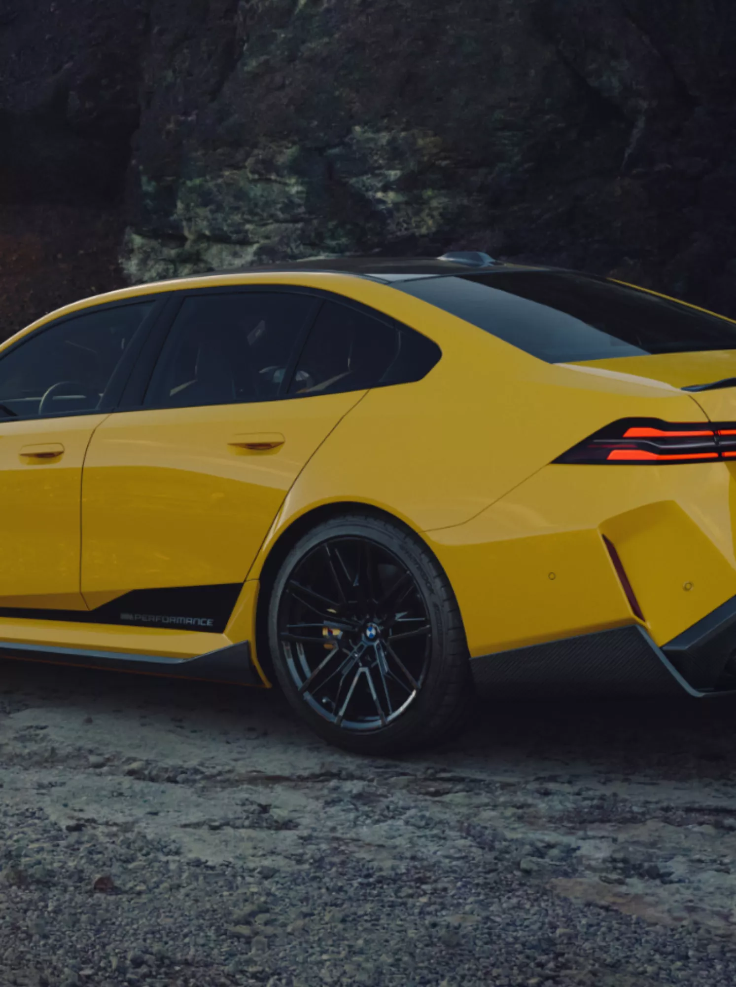 BMW M4 mit BMW M Performance Folierung Motorsport steht an einem Fluss mit Bergen im Hintergrund
