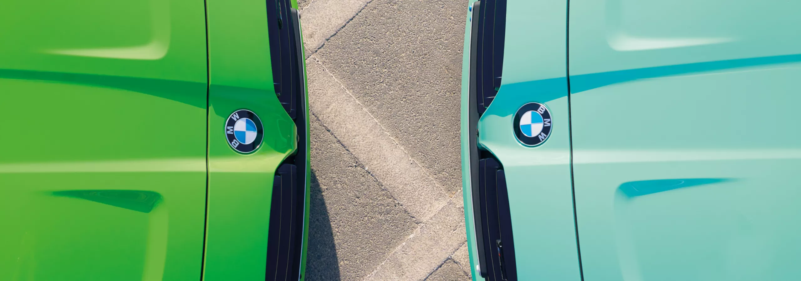 Zwei BMW M3 in BMW Individual Mint Green und Verde Mantis stehen sich gegenüber