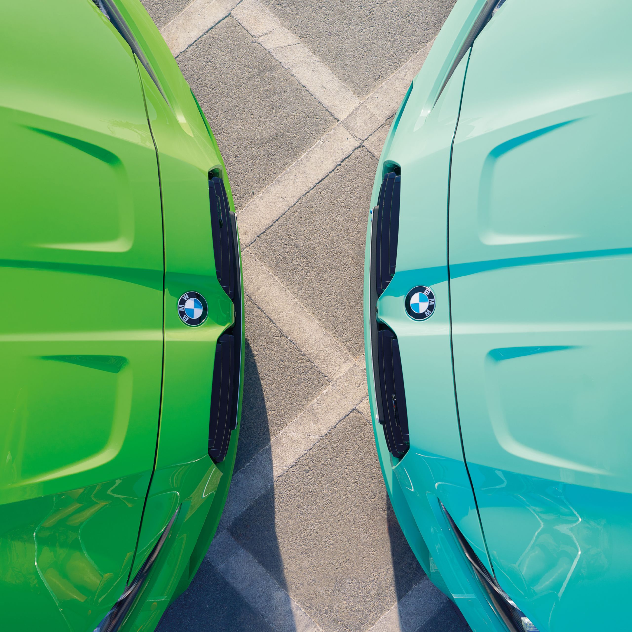 Twee BMW M3's in de kleur BMW Individual Mint Green en Verde Mantis staan tegenover elkaar