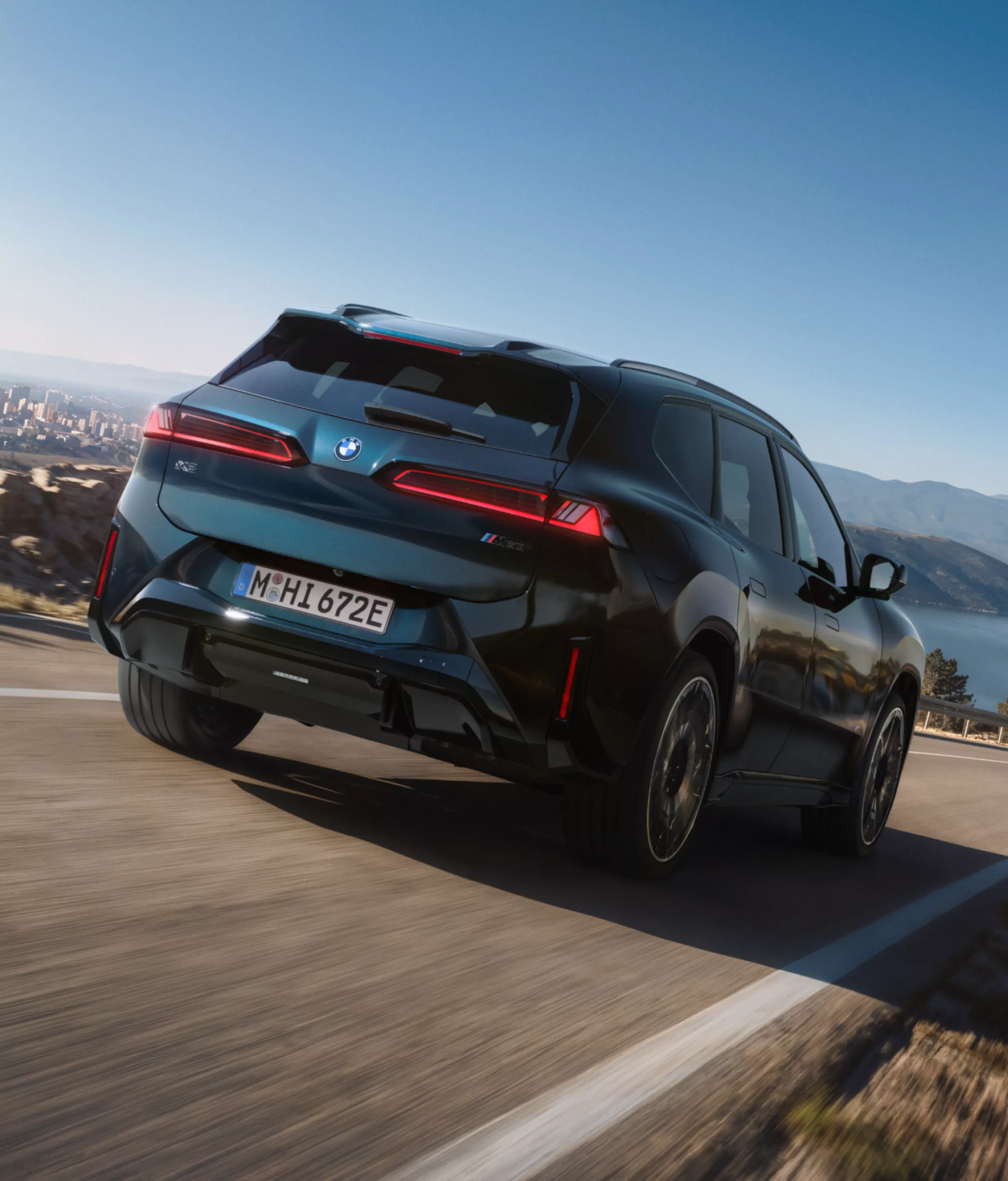 BMW iX3 M60 xDrive in a dynamic driving situation from the front perspective