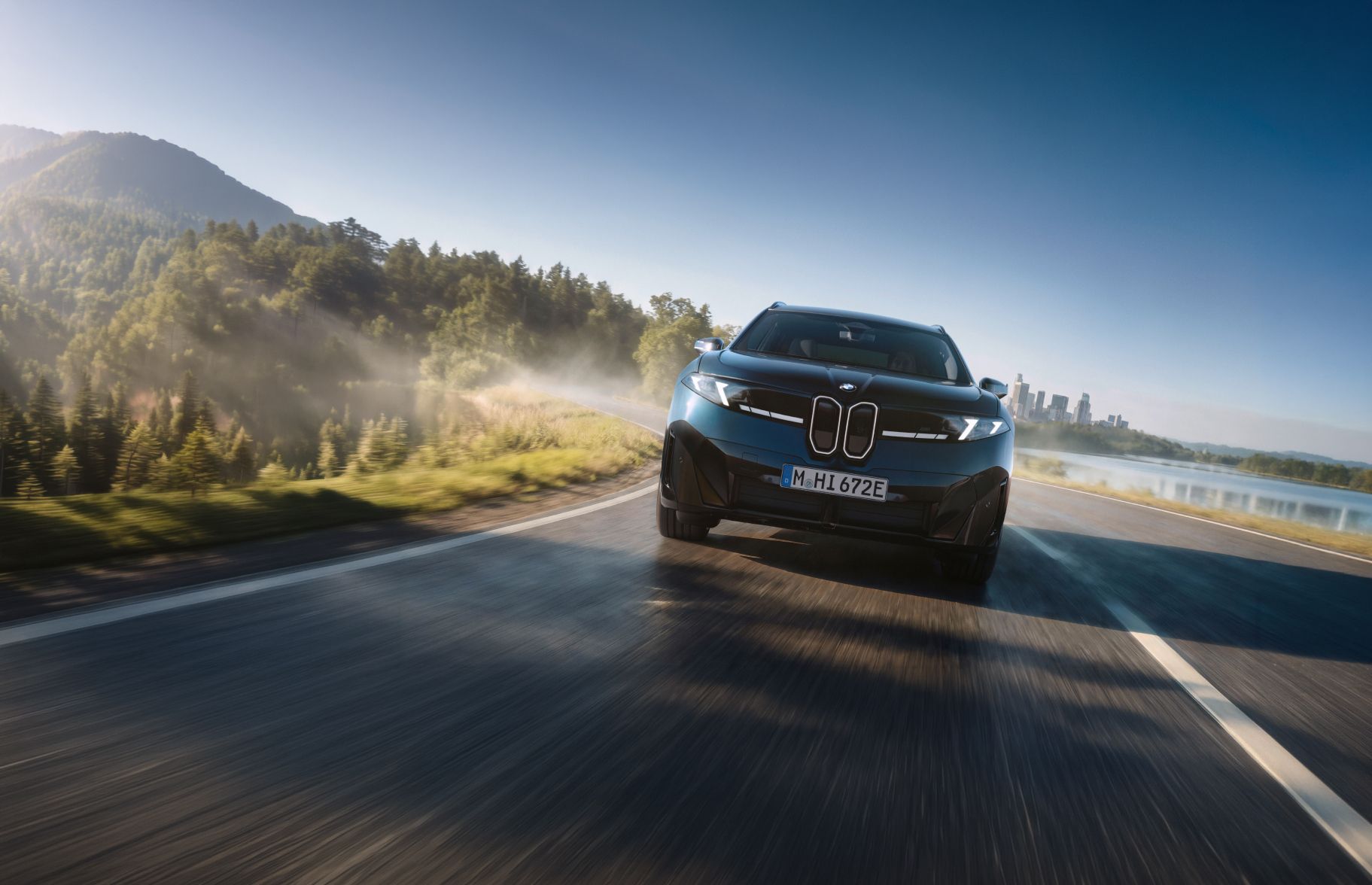 The BMW iX3 M60 xDrive driving down a slick road