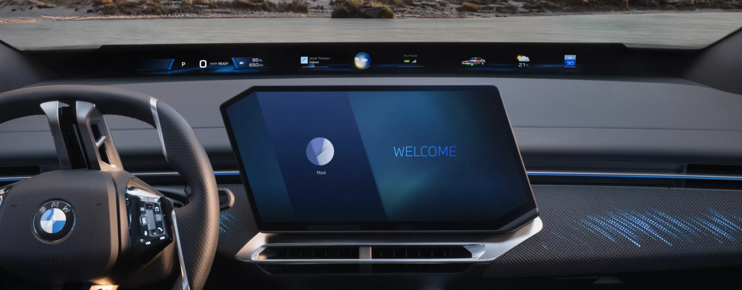 BMW iX4 50 xDrive interior with colour-illuminated dashboard and ambient lighting.