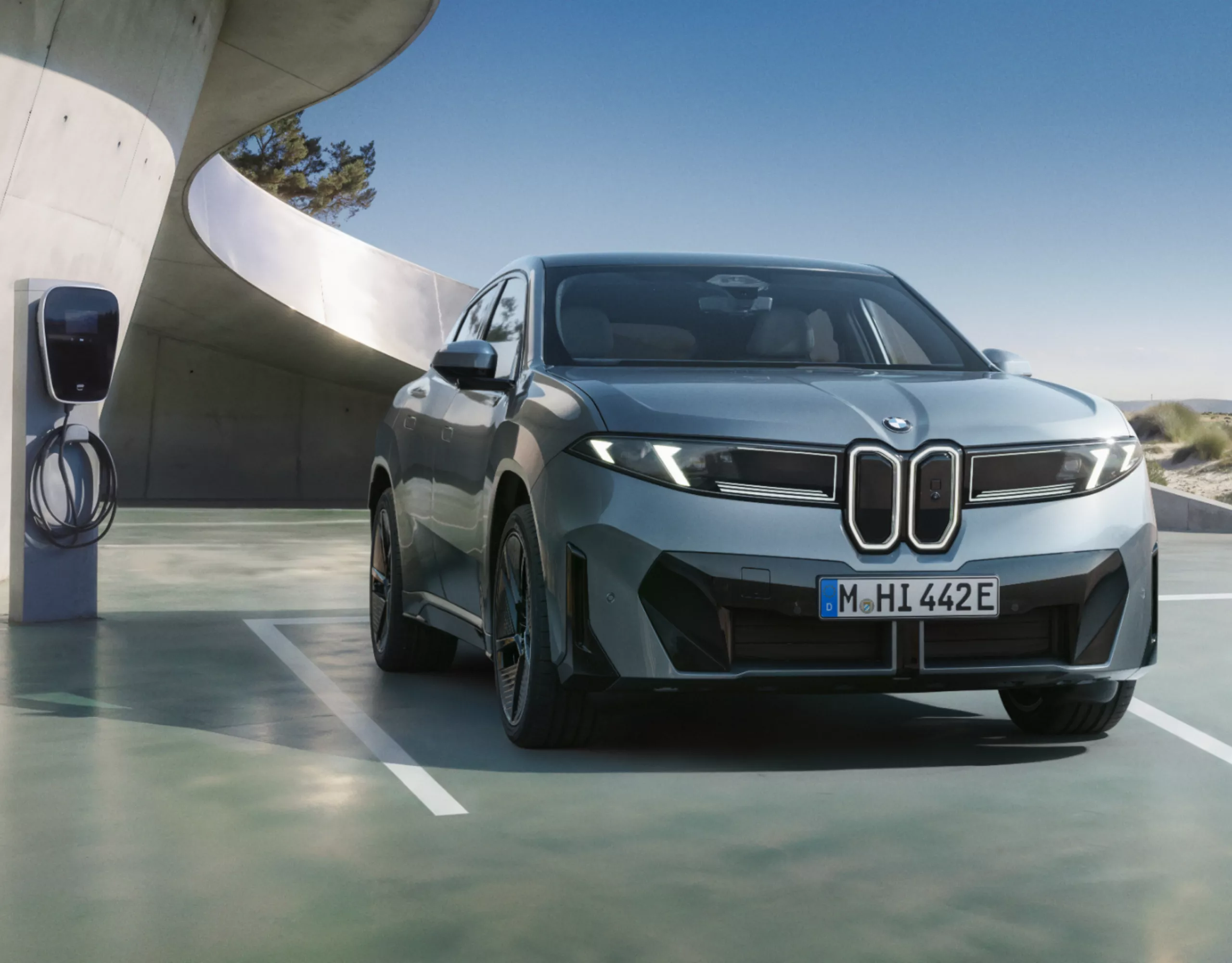 BMW iX4 50 xDrive charging at a charging station