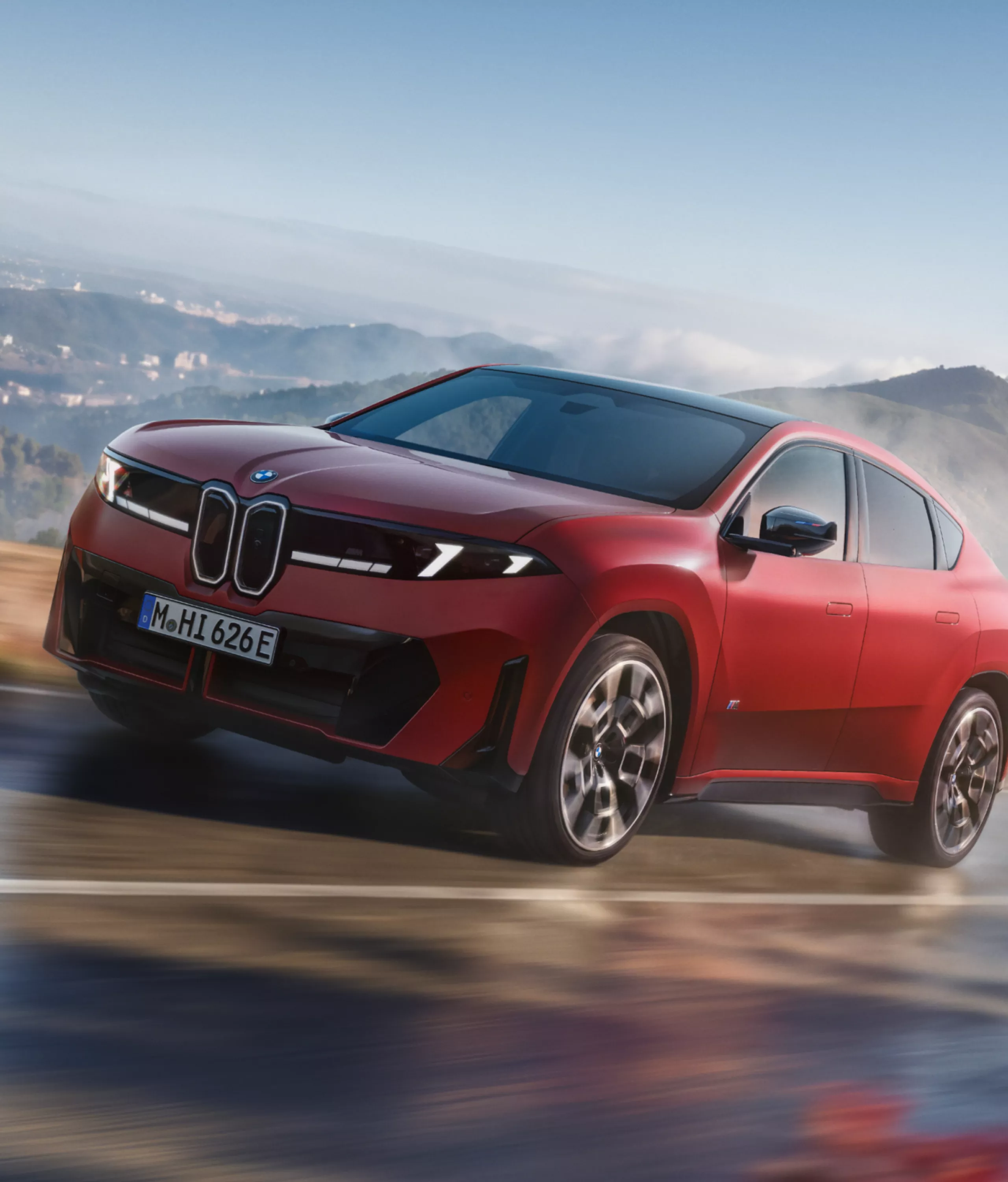 La BMW iX4 M60 xDrive dans un virage, illustrant le fonctionnement de la suspension adaptative M ADAPTIVE