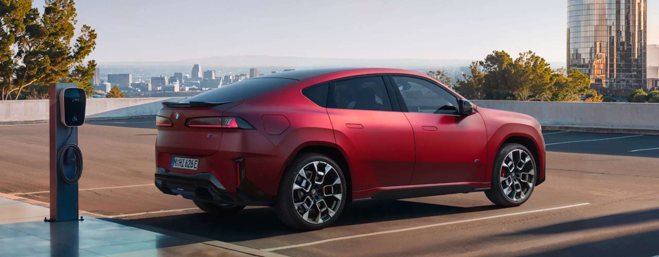BMW iX4 M60 xDrive charging at a charging station