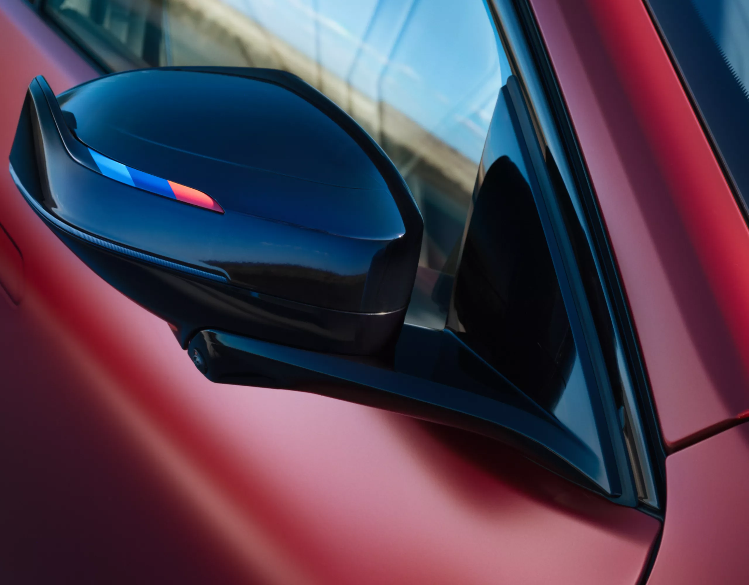Close-up of the new exterior mirror design with black M Mirror caps on the BMW iX4 M60 xDrive