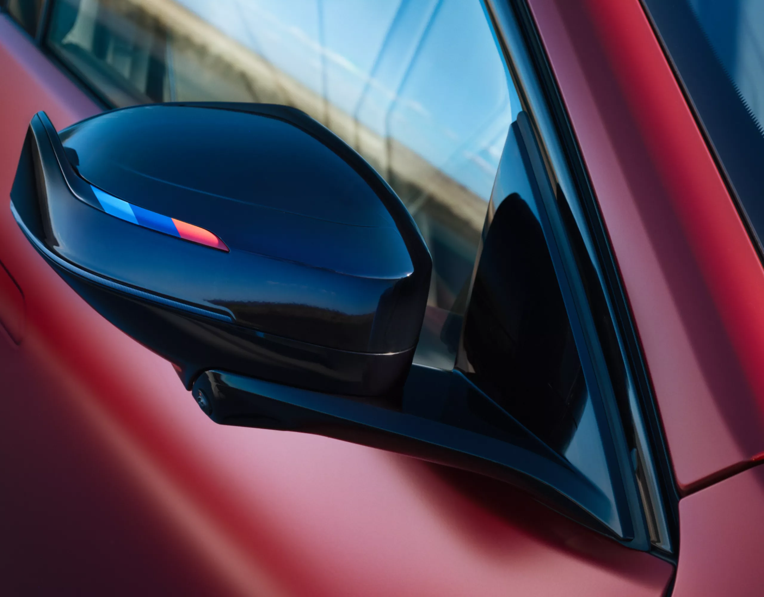 Close-up of the new exterior mirror design with black M Mirror caps on the BMW iX4 M60 xDrive