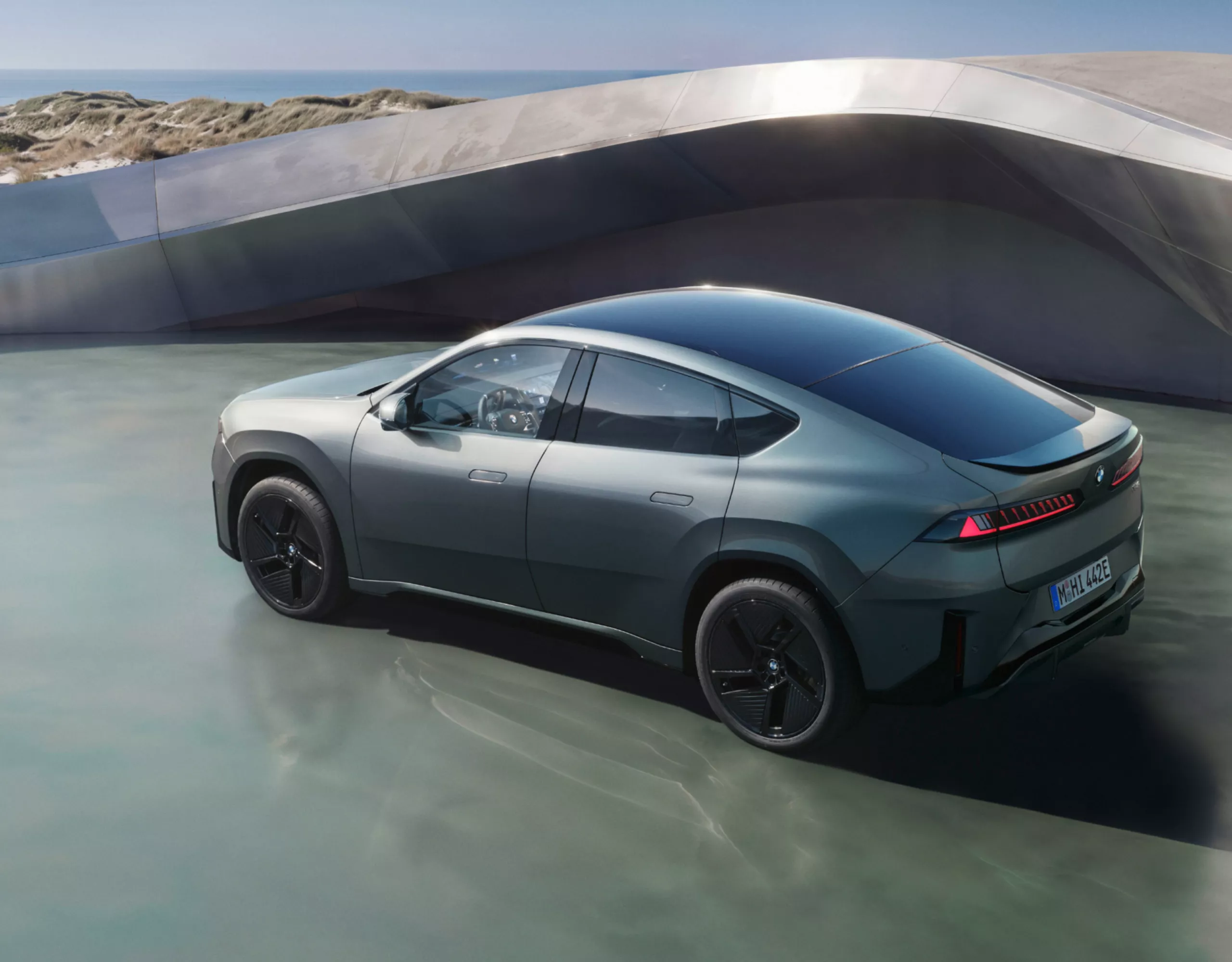 BMW iX4 50 xDrive standing in a natural landscape as a teaser for the vehicle page