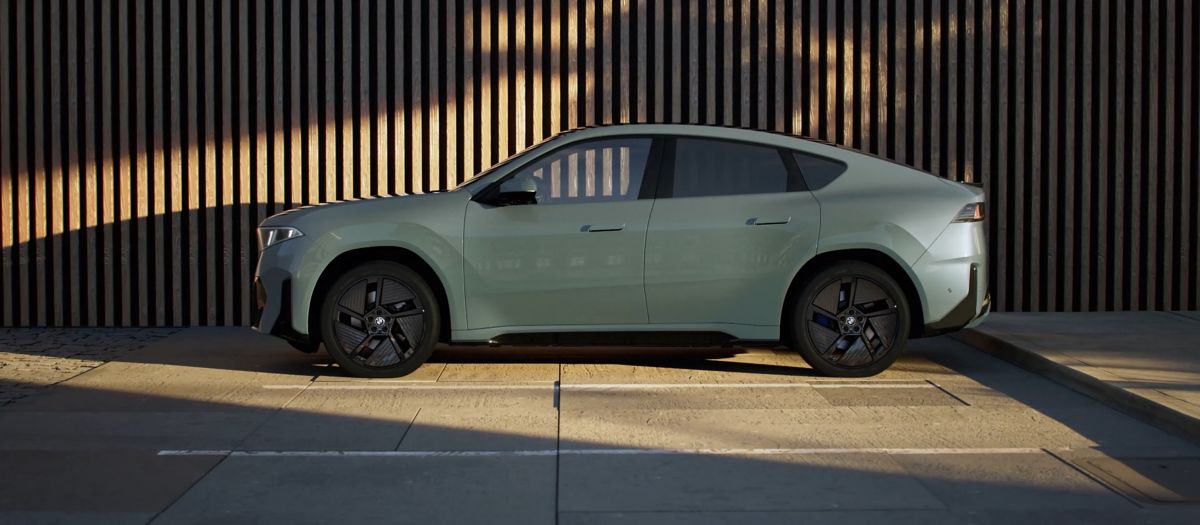 Side profile of the BMW iX4 showing its sloping SUV coupe roofline