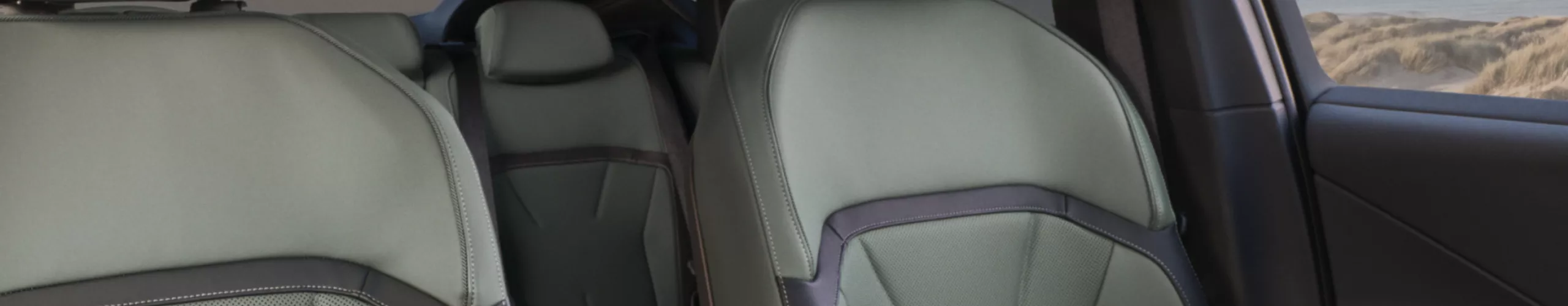 Interior view from the rear seats through the panoramic glass roof with climate comfort glass in the BMW iX4 50 xDrive.