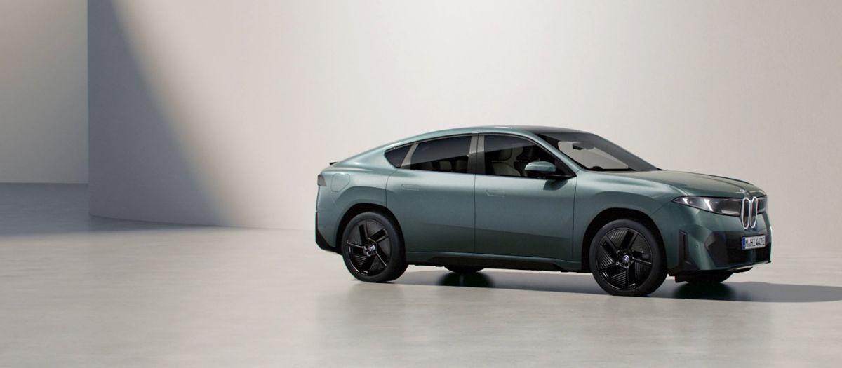 Grey 2027 BMW iX4 electric SUV coupe, side three-quarter view, coming to BMW of Darien