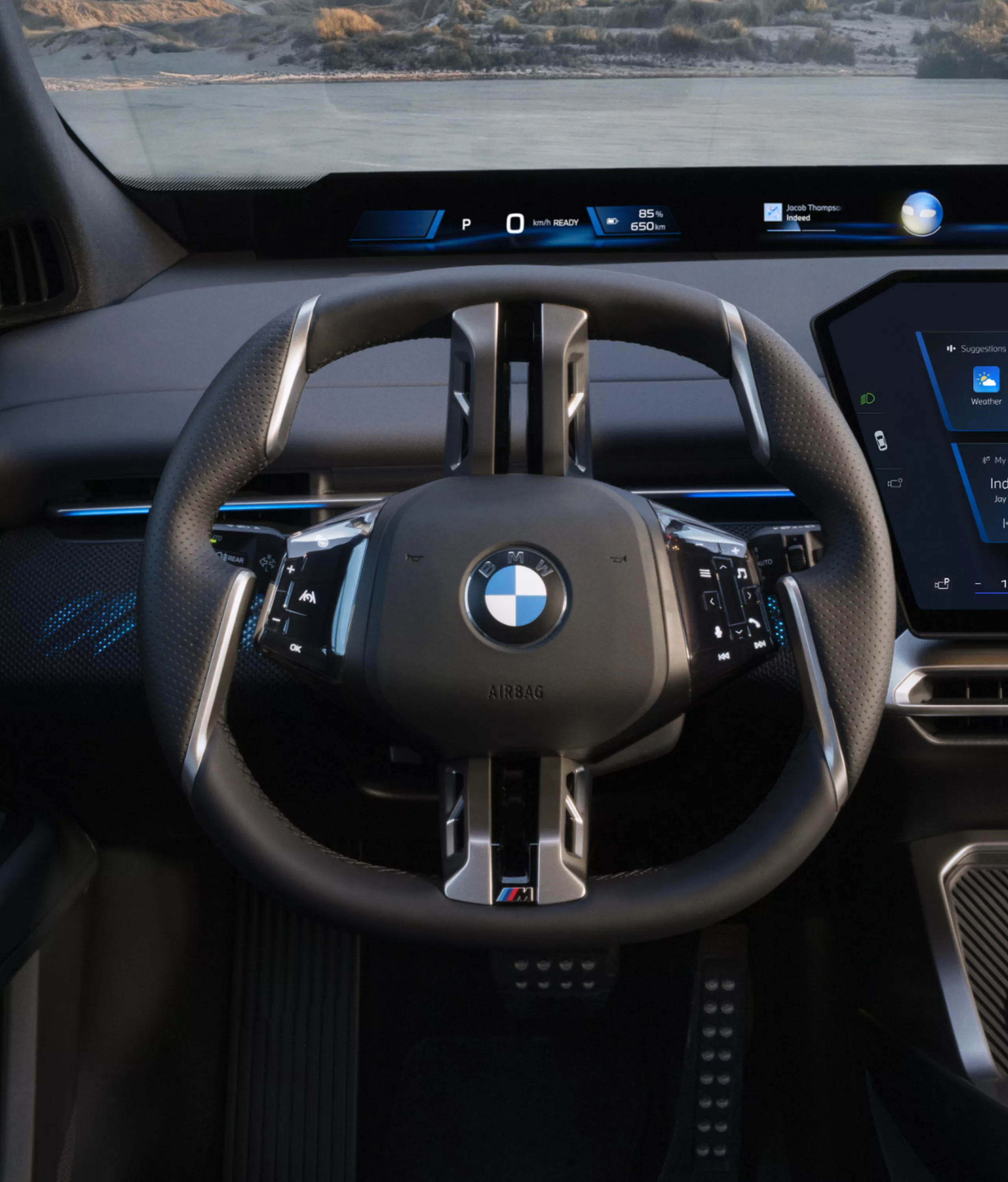 BMW multifunction steering wheel in the BMW iX4 50 xDrive cockpit.