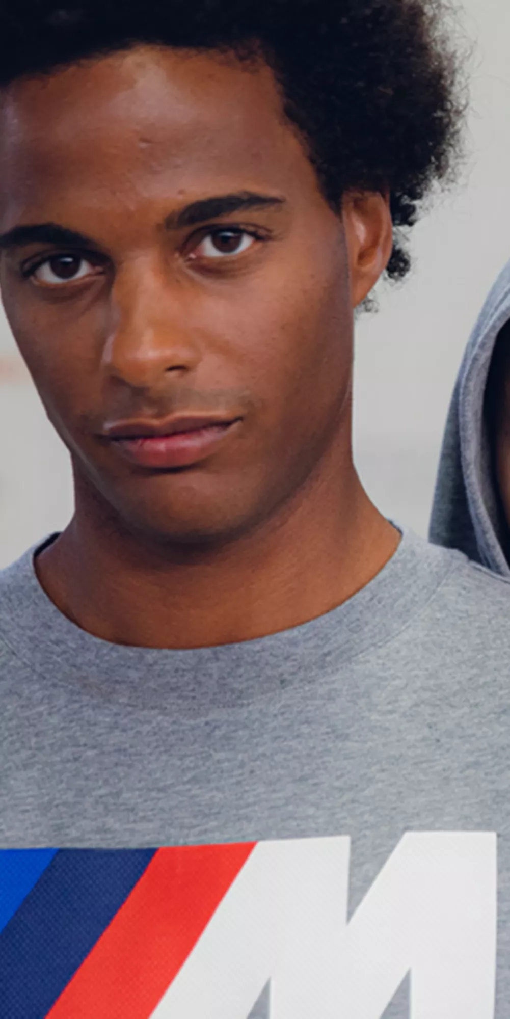 BMW Lifestyle BMW M Motorsport Collection featuring a hoodie, shorts, and t-shirt, worn by two young persons
