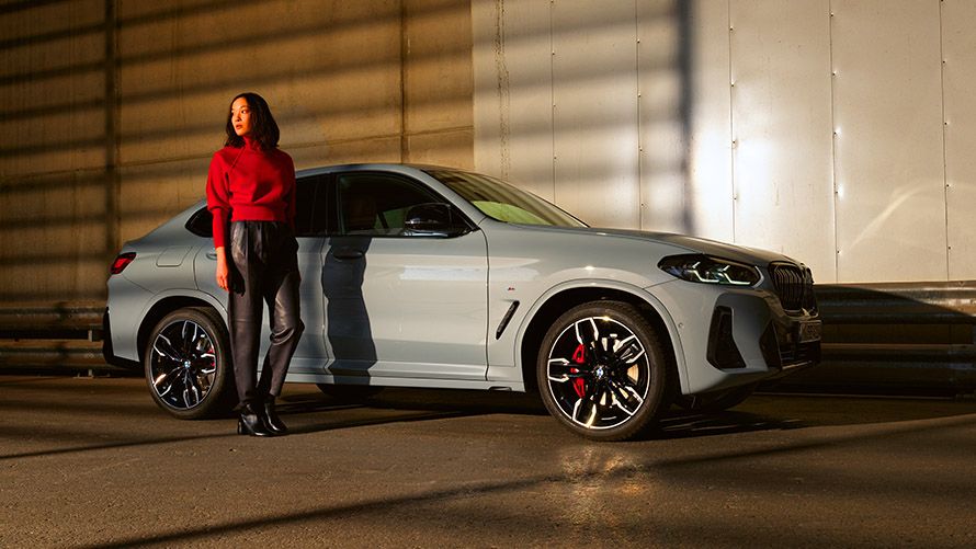 BMW Financial Services man and woman sitting in BMW in front of mountain landscape 