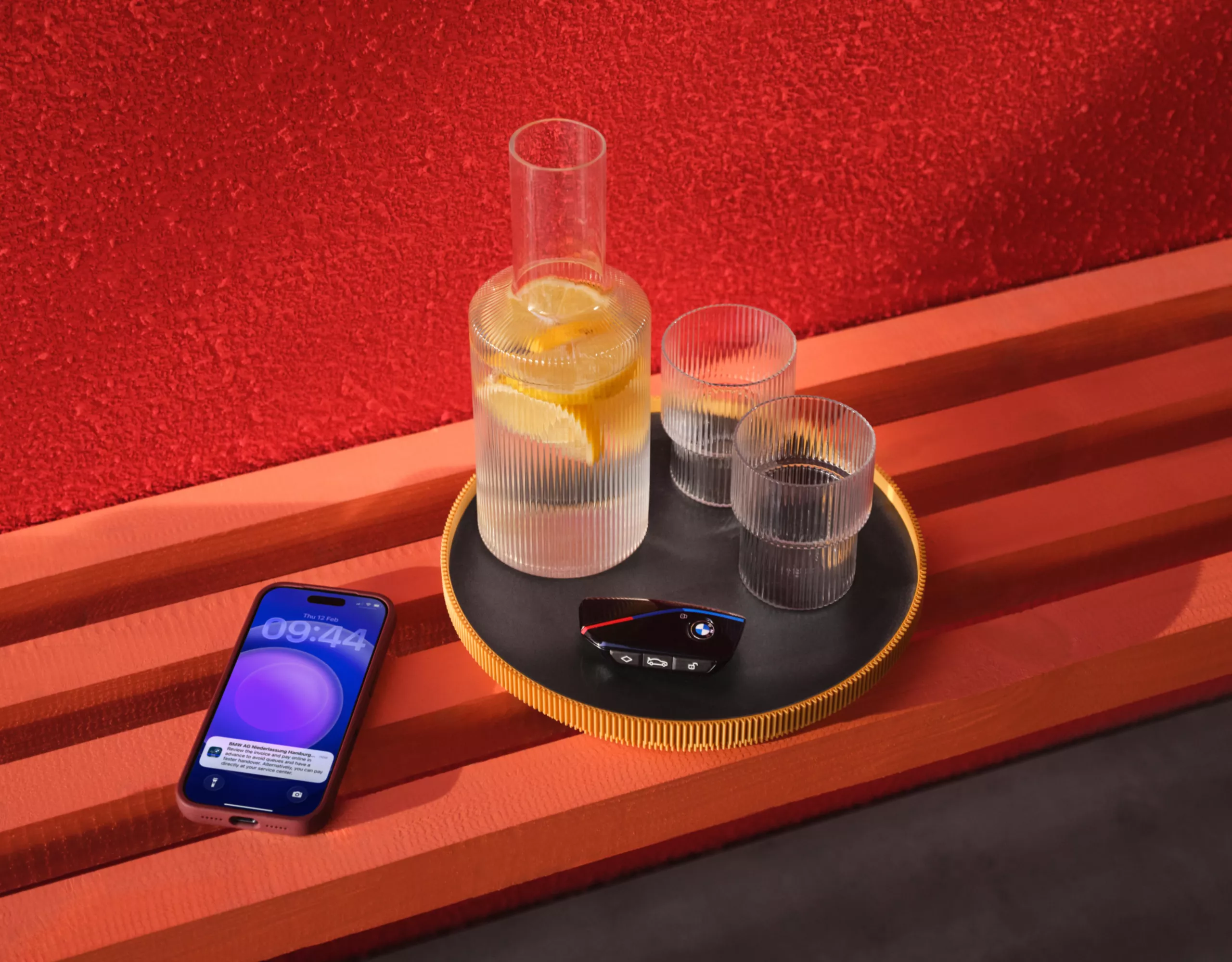 A tray with drinks and a smartphone against a red background