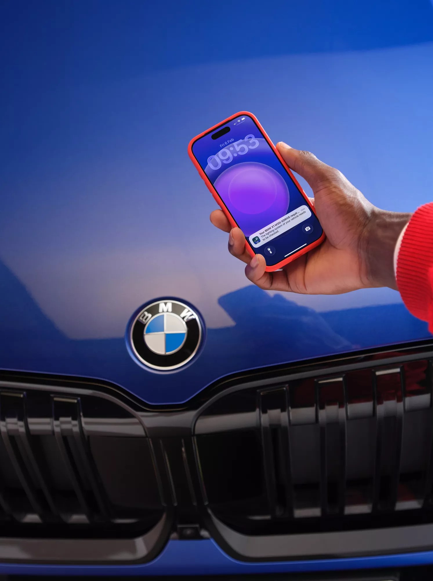 A smartphone is held up against a purple bonnet