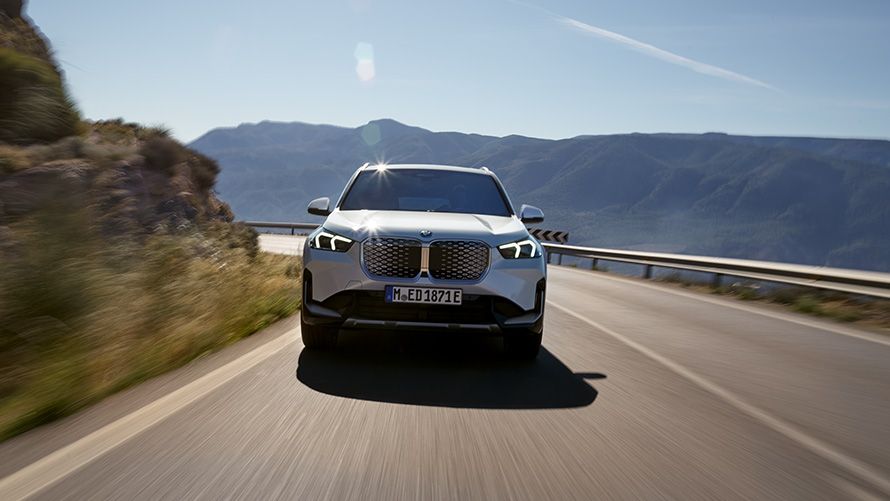 BMW Financial Services, BMW Ασφάλιση Αυτοκινήτου, πλαϊνή λήψη τριών τετάρτων με γυναίκα μπροστά σε ορεινό τοπίο 