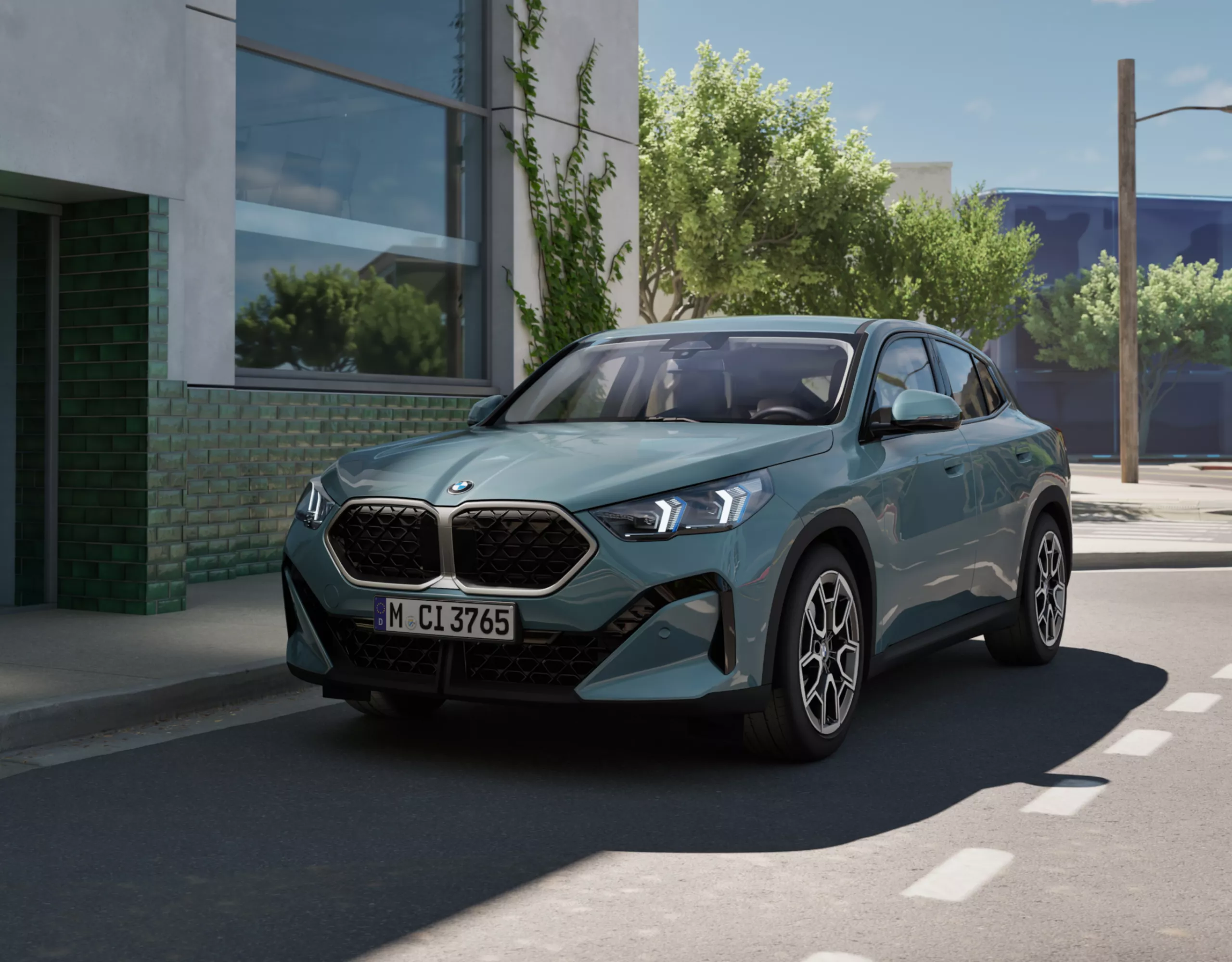 BMW X2 U10 SUV devant un complexe de bâtiments modernes en centre-ville