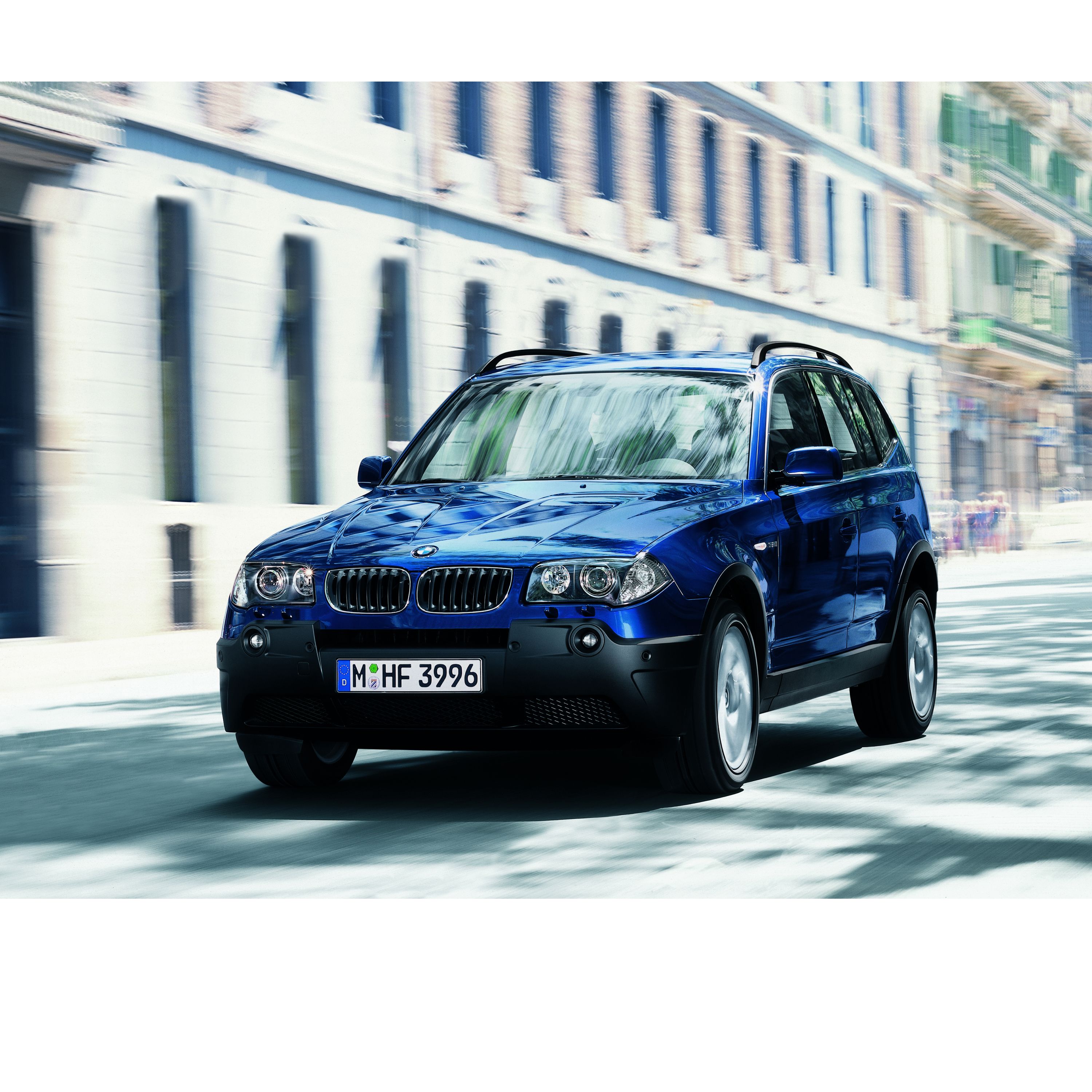 BMW X3 E83 SUV su una strada di fronte a uno sfondo del centro storico di una città europea