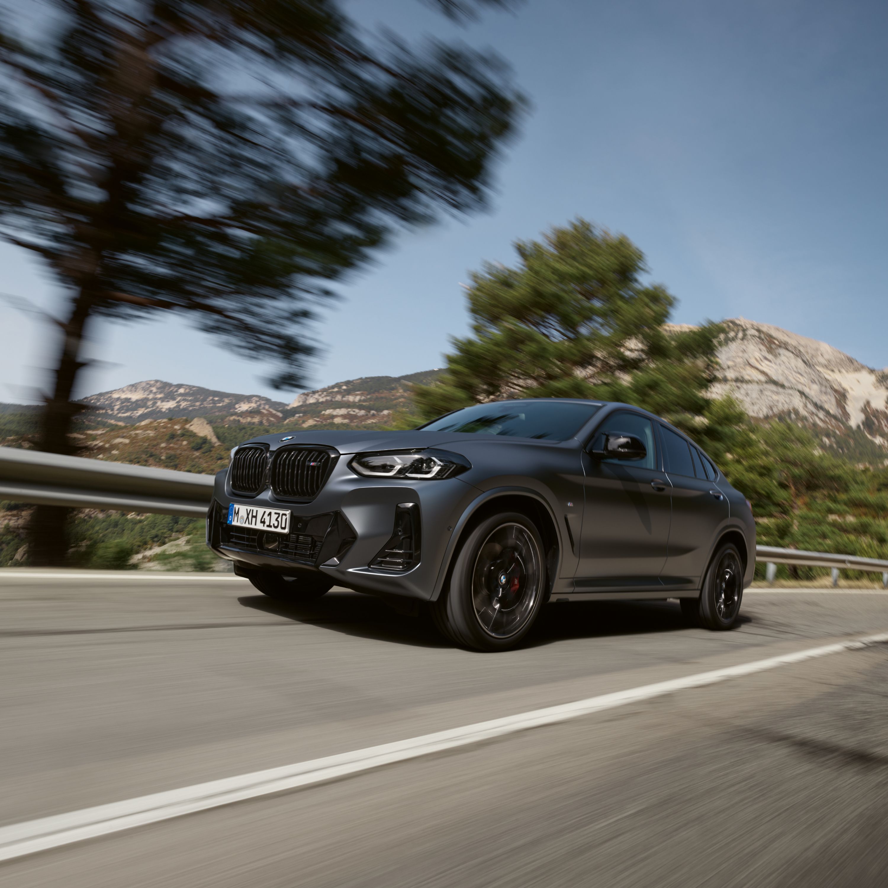 BMW X4 G02 SUV na horském průsmyku před alpskou krajinou