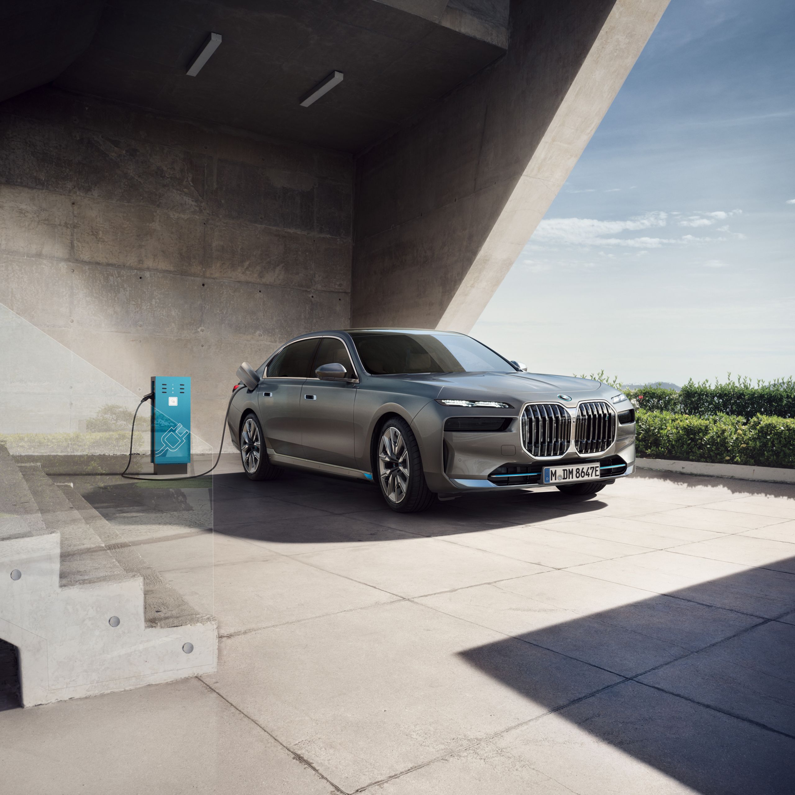 BMW i7 aan laadpaal voor kantoorgebouw
