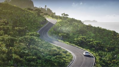 i Series Hub Sustainability – clean, up-hill serpentine road through a forested area along the coast
