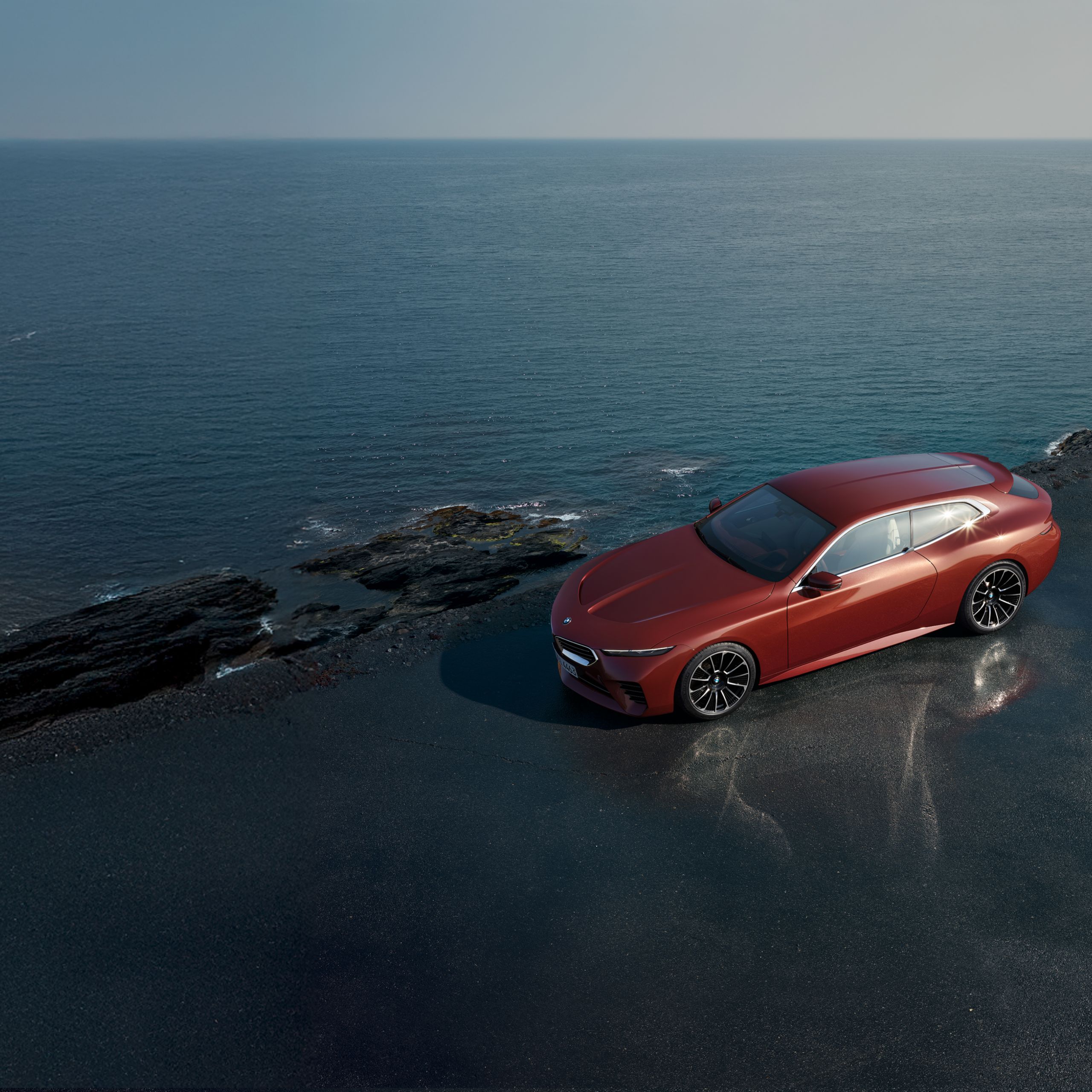 La BMW Concept Speedtop se trouve sur une route côtière mouillée, le soleil se reflète dans les vitres 