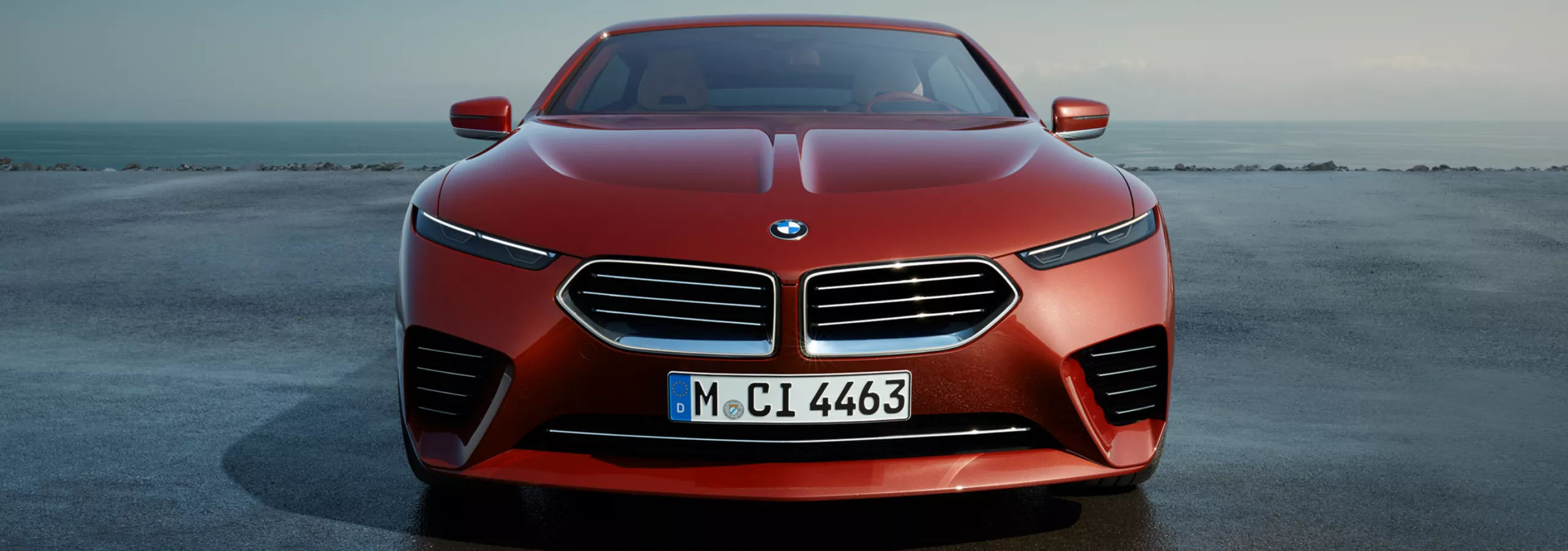 Pohled zepředu na BMW Speedtop stojící na parkovacím místě podél pobřeží