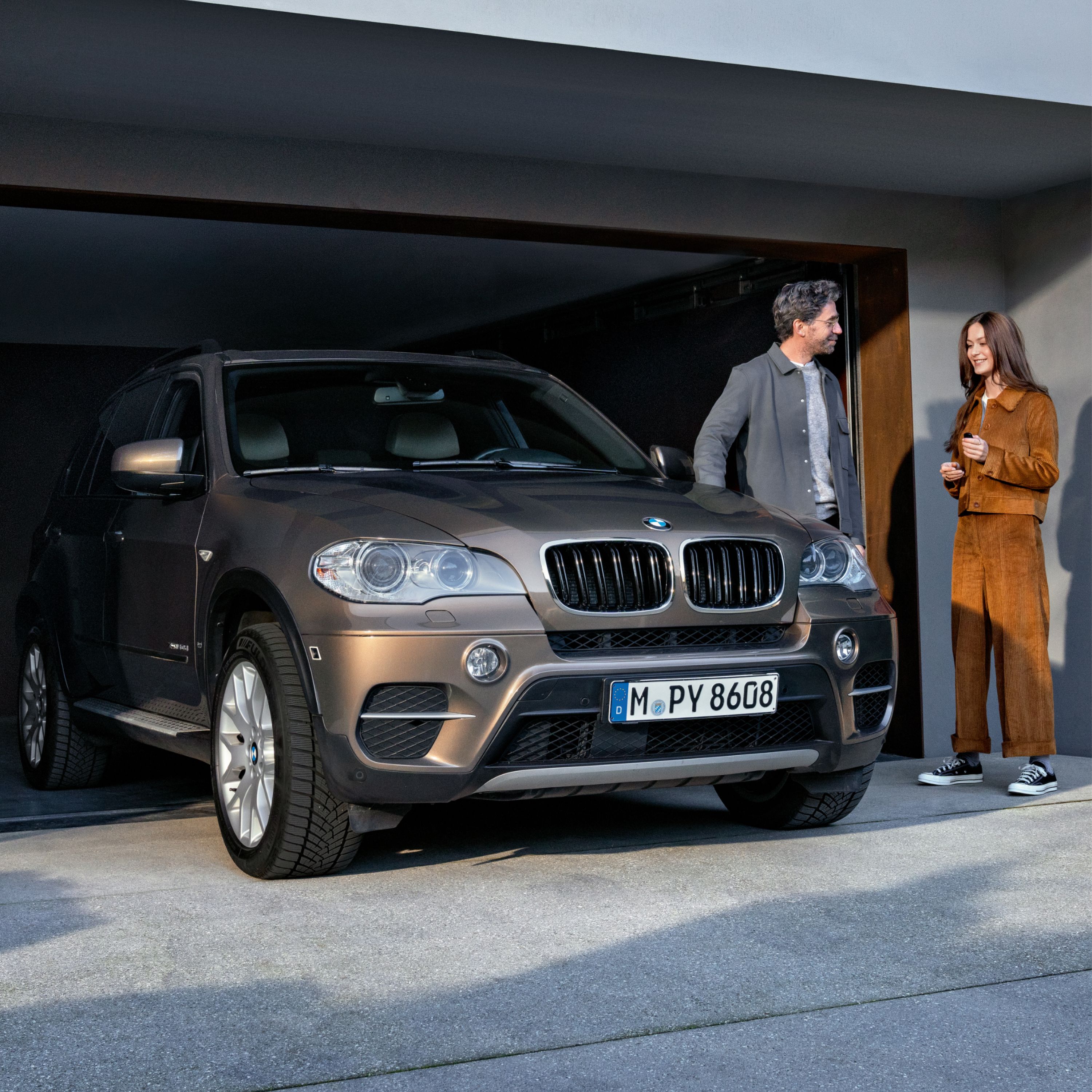 BMW Szerviz 5+, egy modellek társaságában látható BMW áll egy garázs előtt