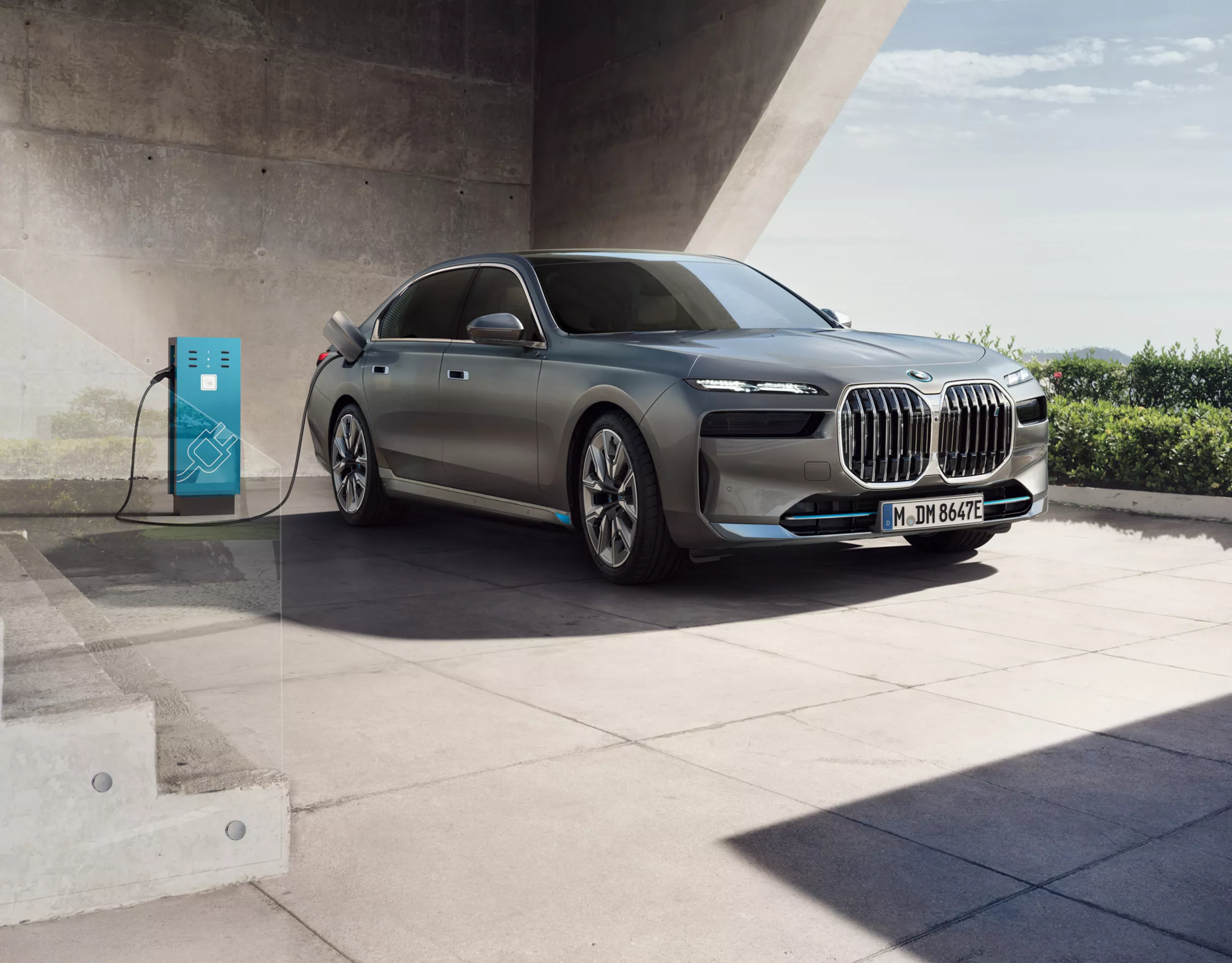 BMW i7 connected to a charging station in front of an office building