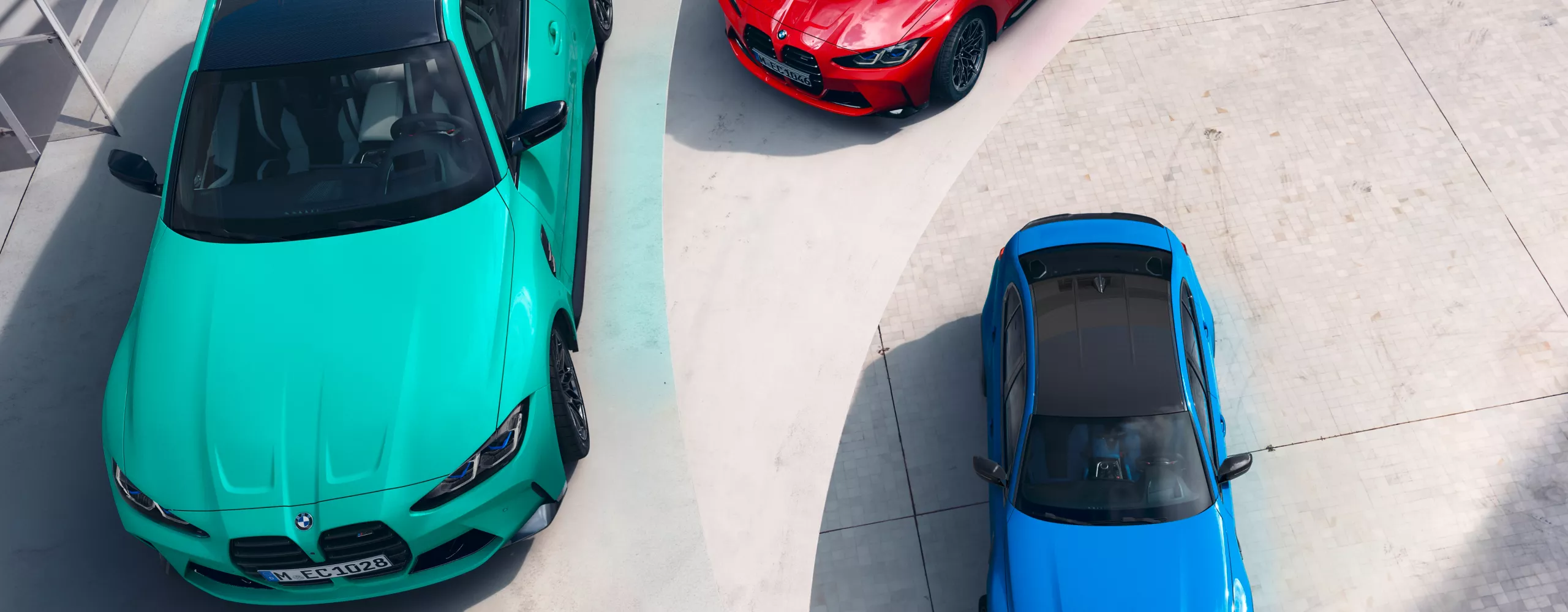 Trzy samochody BMW w fantazyjnych kolorach BMW Individual, widok od góry.