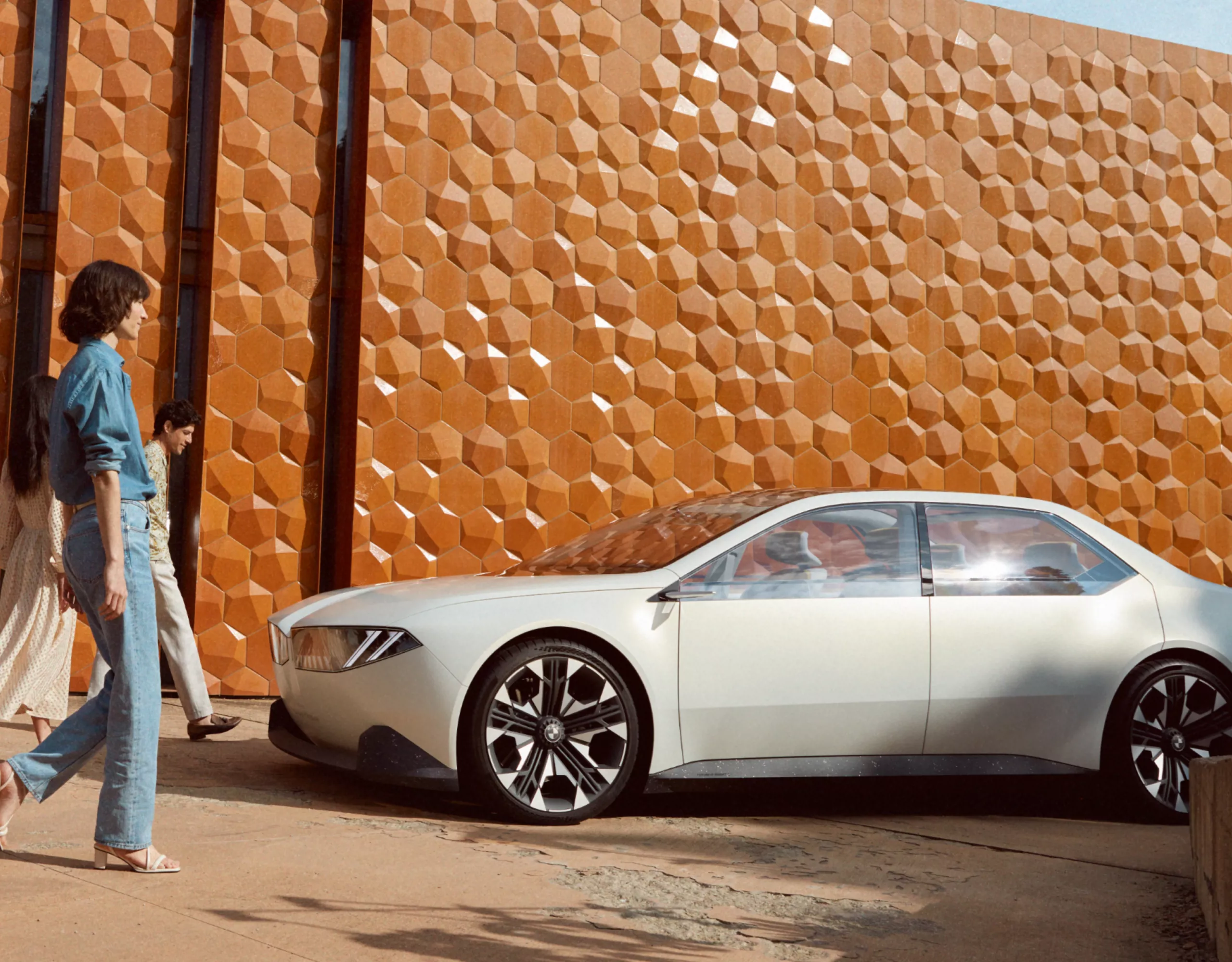 BMW Vision Neue Klasse concept car 2023 exterior 4/5 side view, parking in front of wall, with a woman