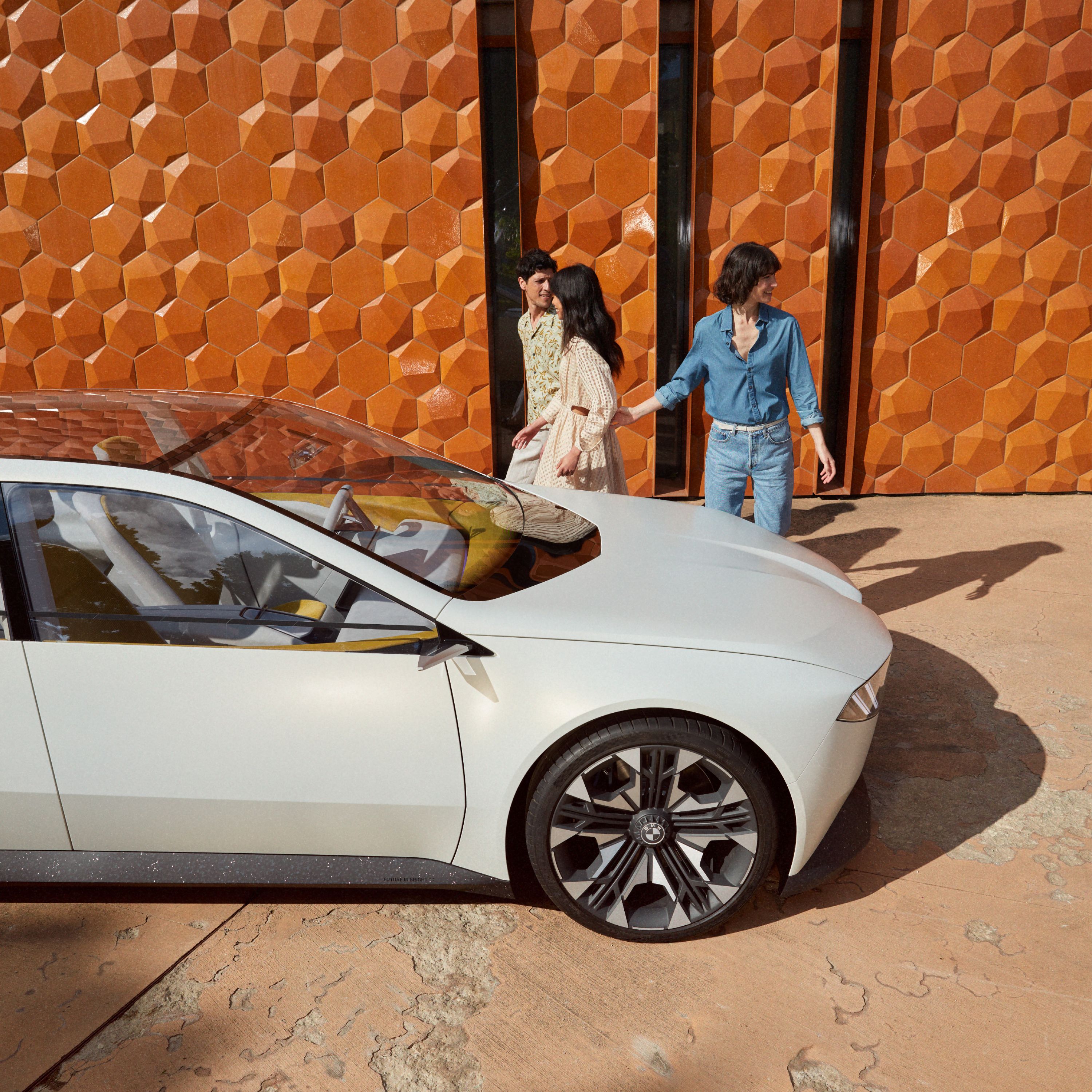 BMW Vision Neue Klasse, Concept car 2023, εξωτερική σχεδίαση, πλαϊνή λήψη, σταθμευμένη μπροστά από τοίχο, με 3 άτομα
