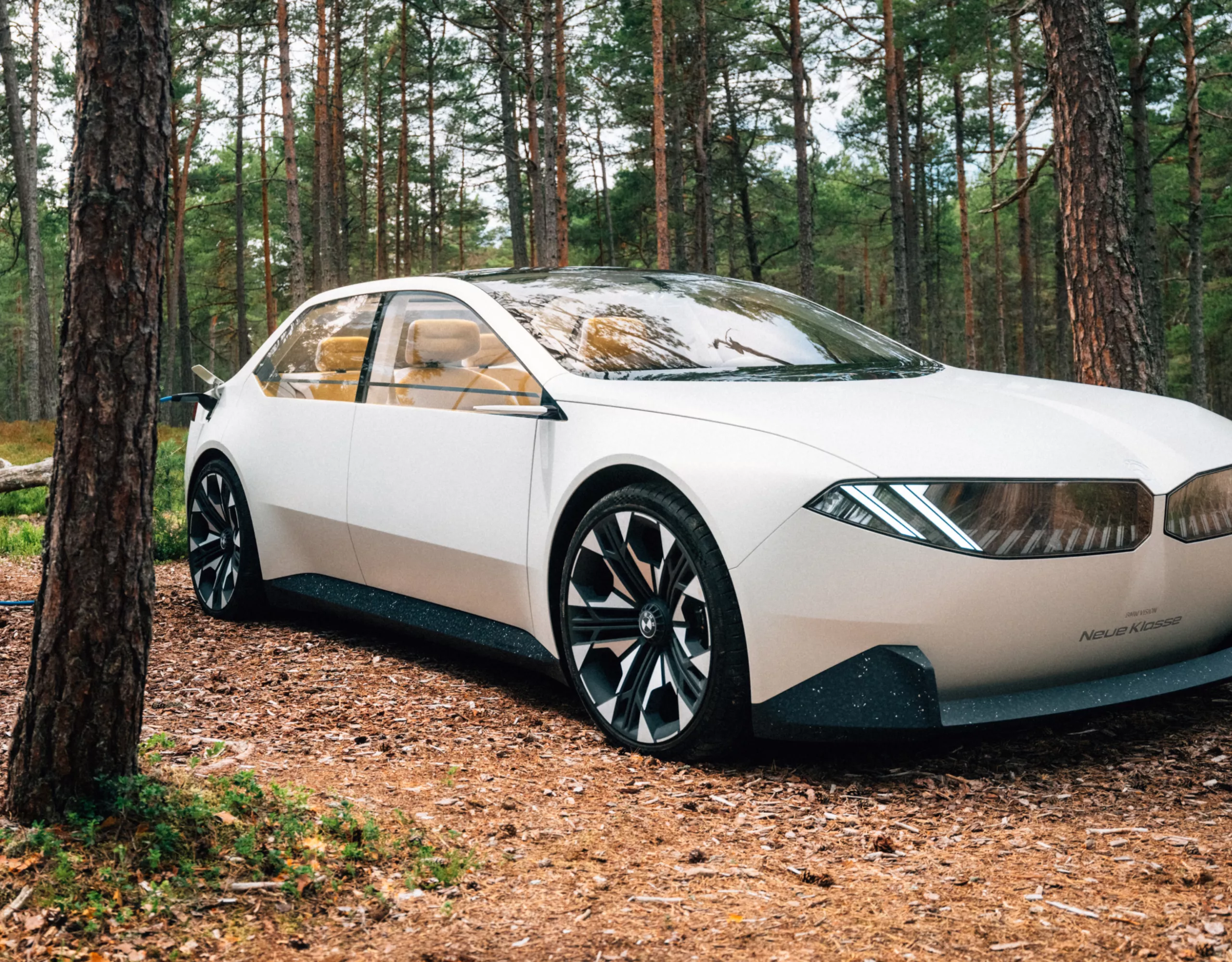 Veículo BMW Vision Neue Klasse 2/3 Concept 2023 exterior 2/3 vista lateral, dirigindo na floresta