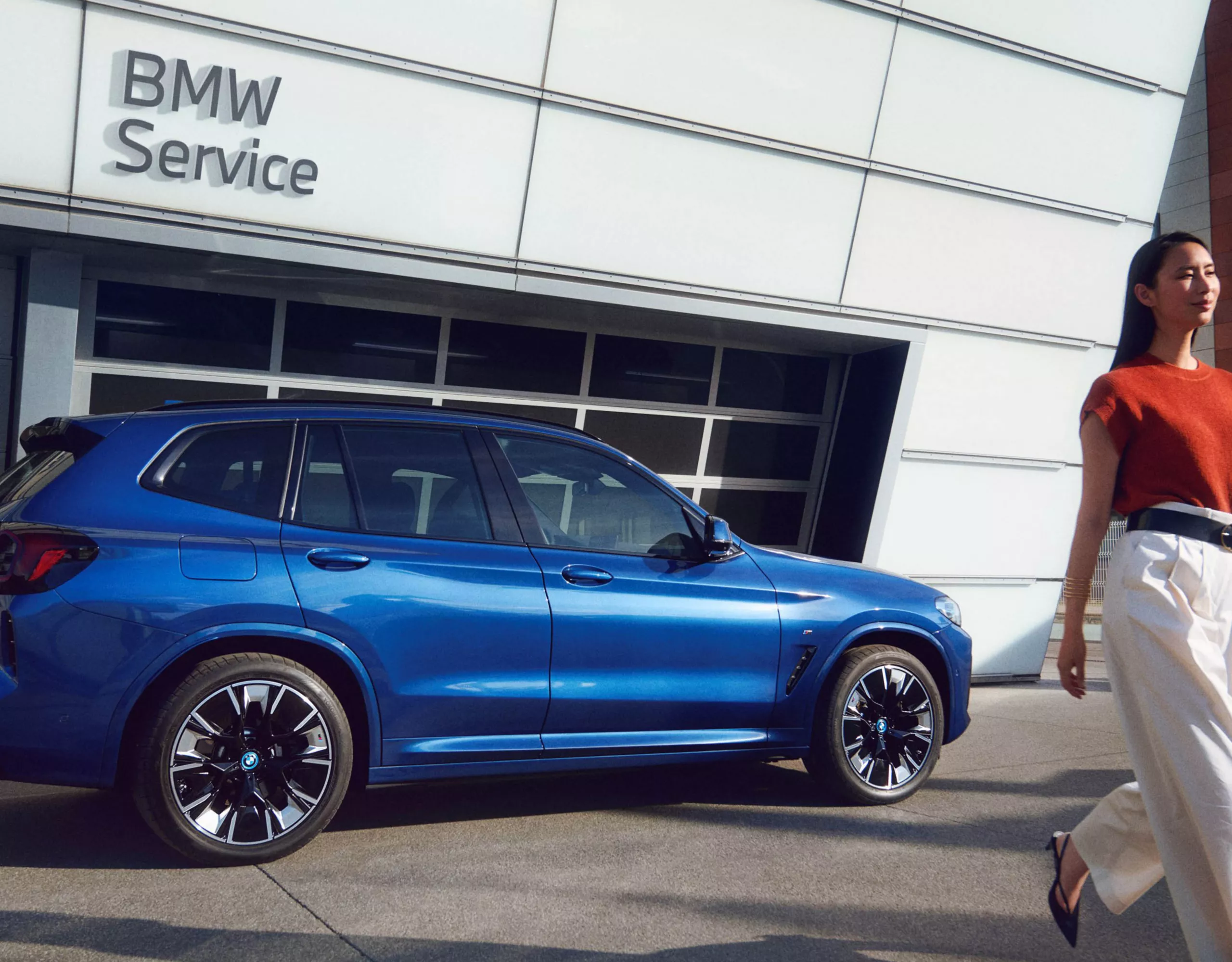 BMW iX3 parkerad utanför en BMW service verkstad. 