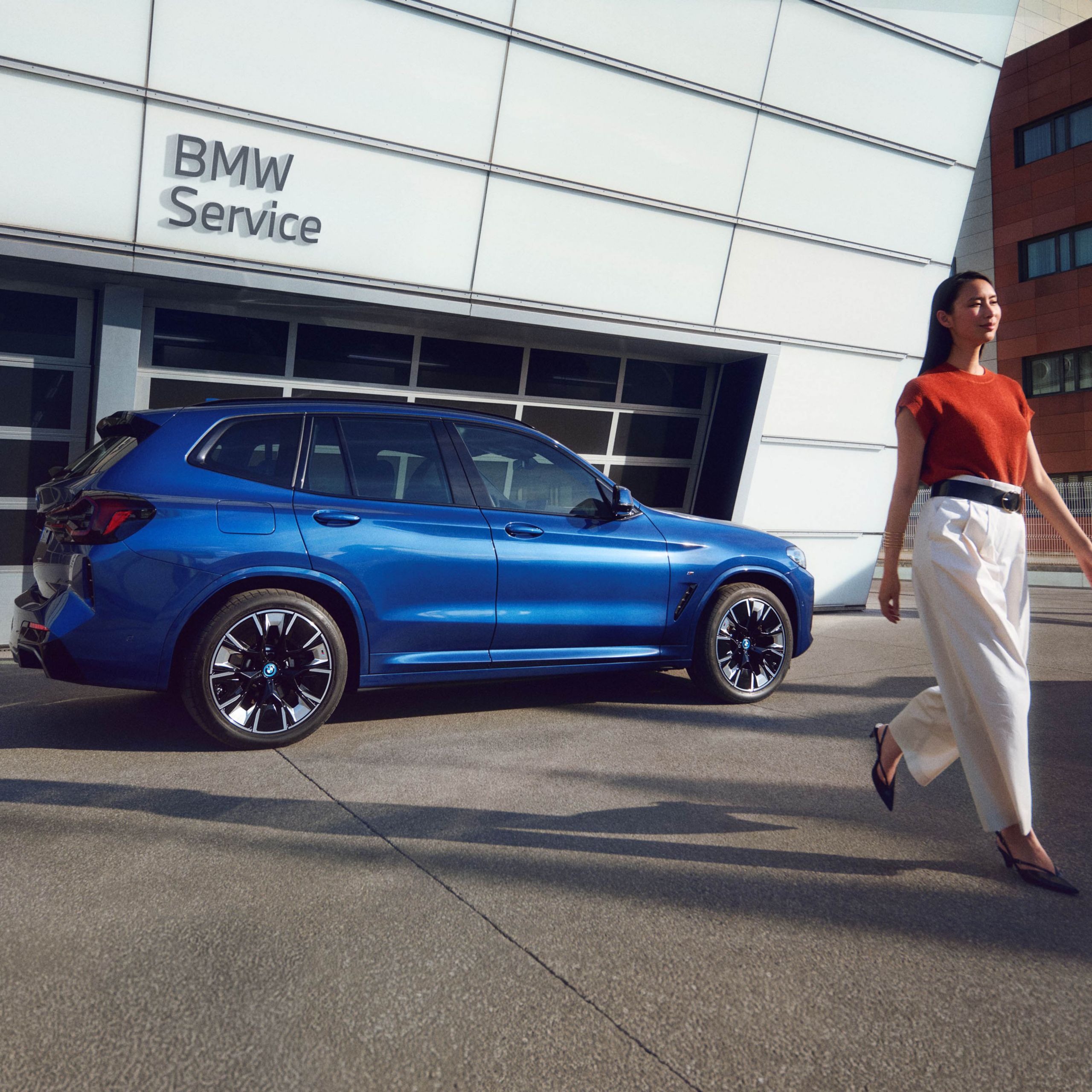 BMW iX3 parkerad utanför en BMW service verkstad. 