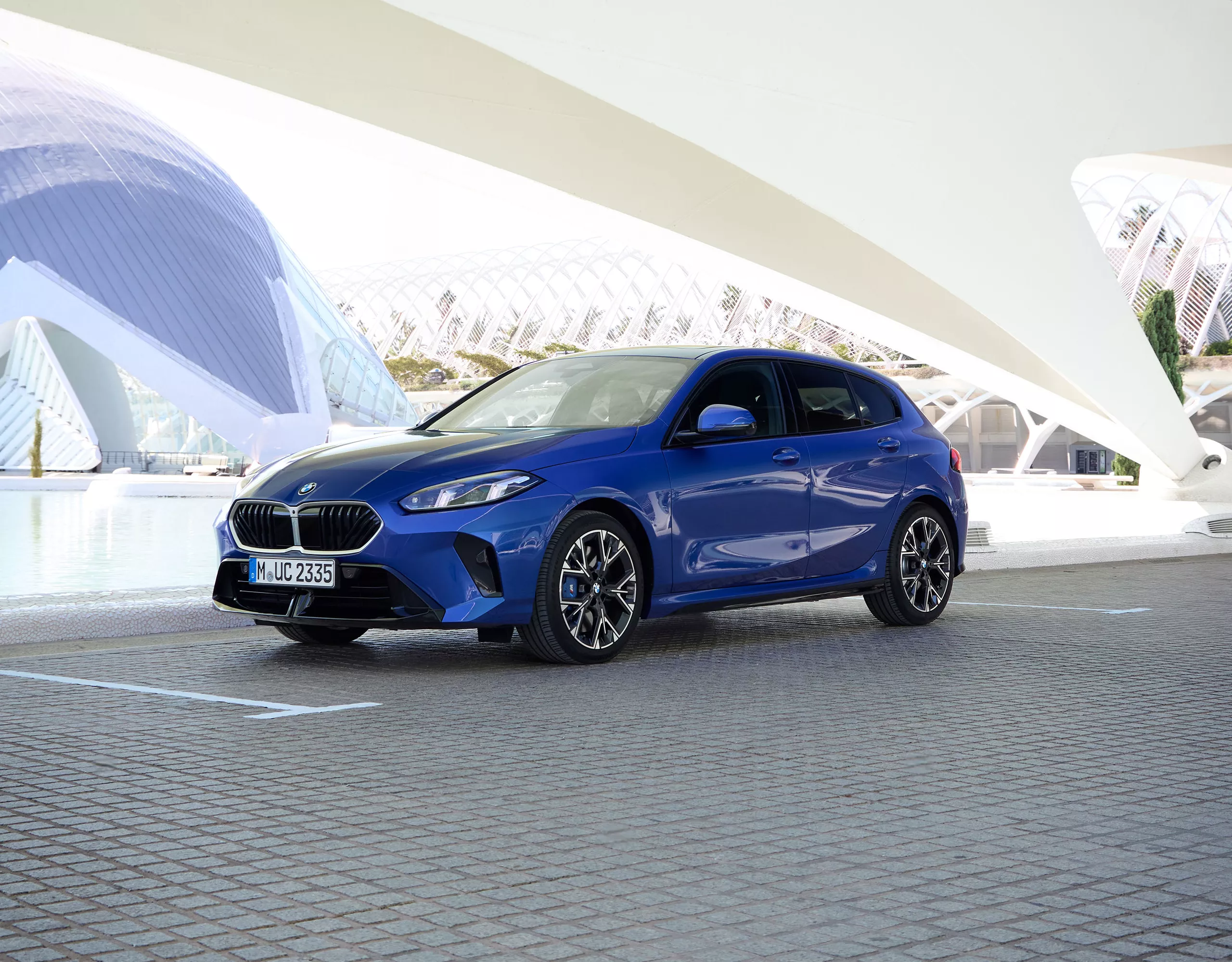 BMW azul estacionado frente a un edificio moderno