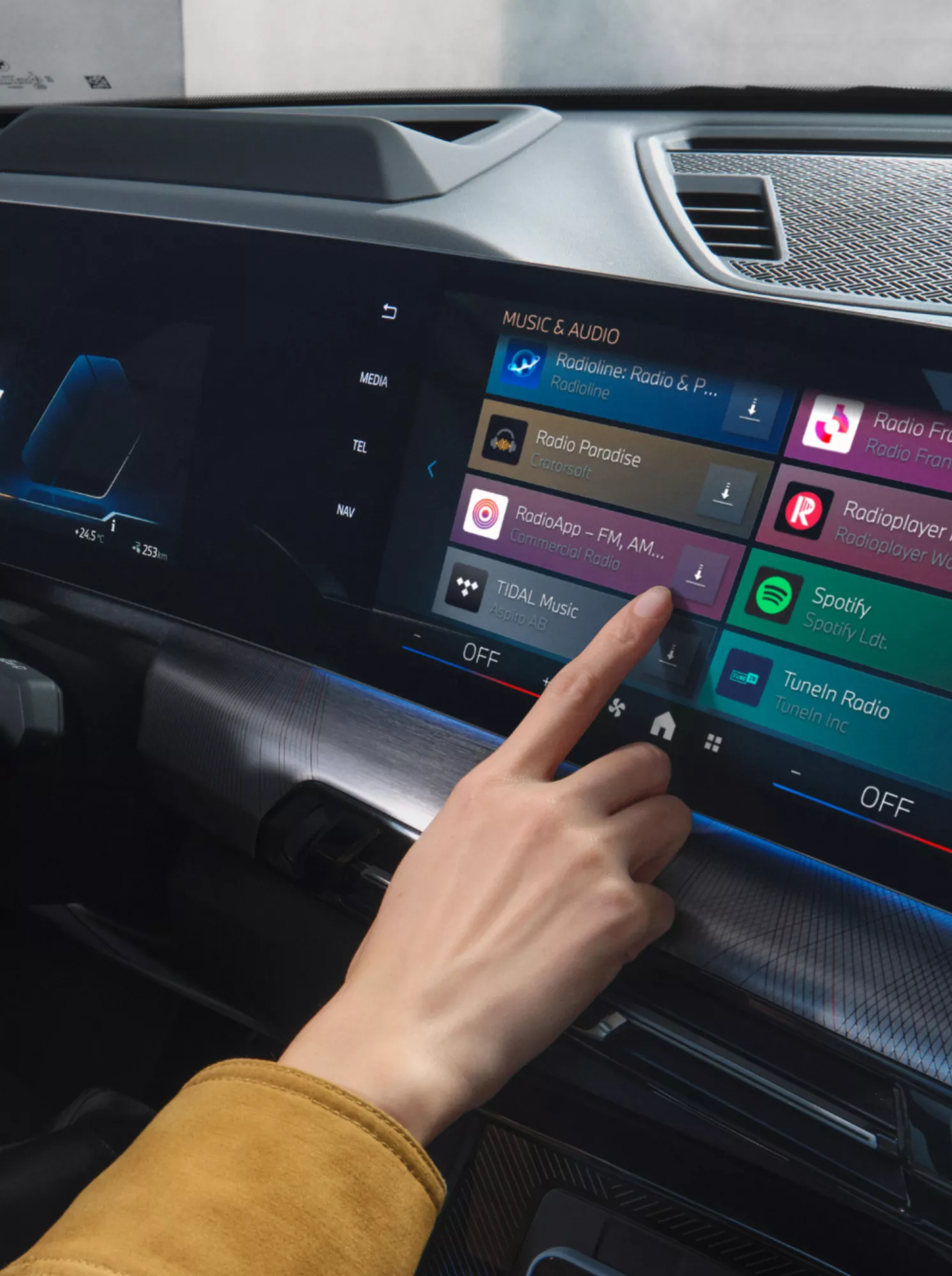 A person is selecting the radio app in the central display of a BMW