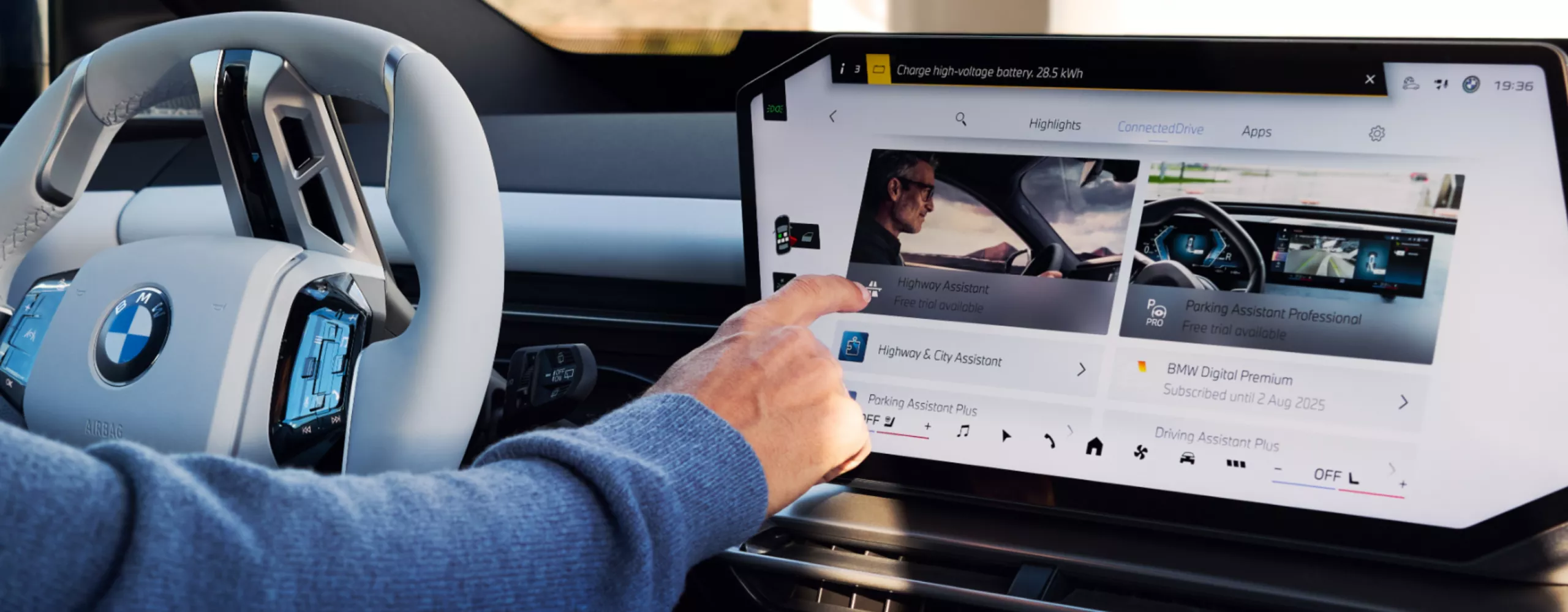 Žmogus naudojasi BMW jutikliniu ekranu norėdamas pasirinkti programėlę