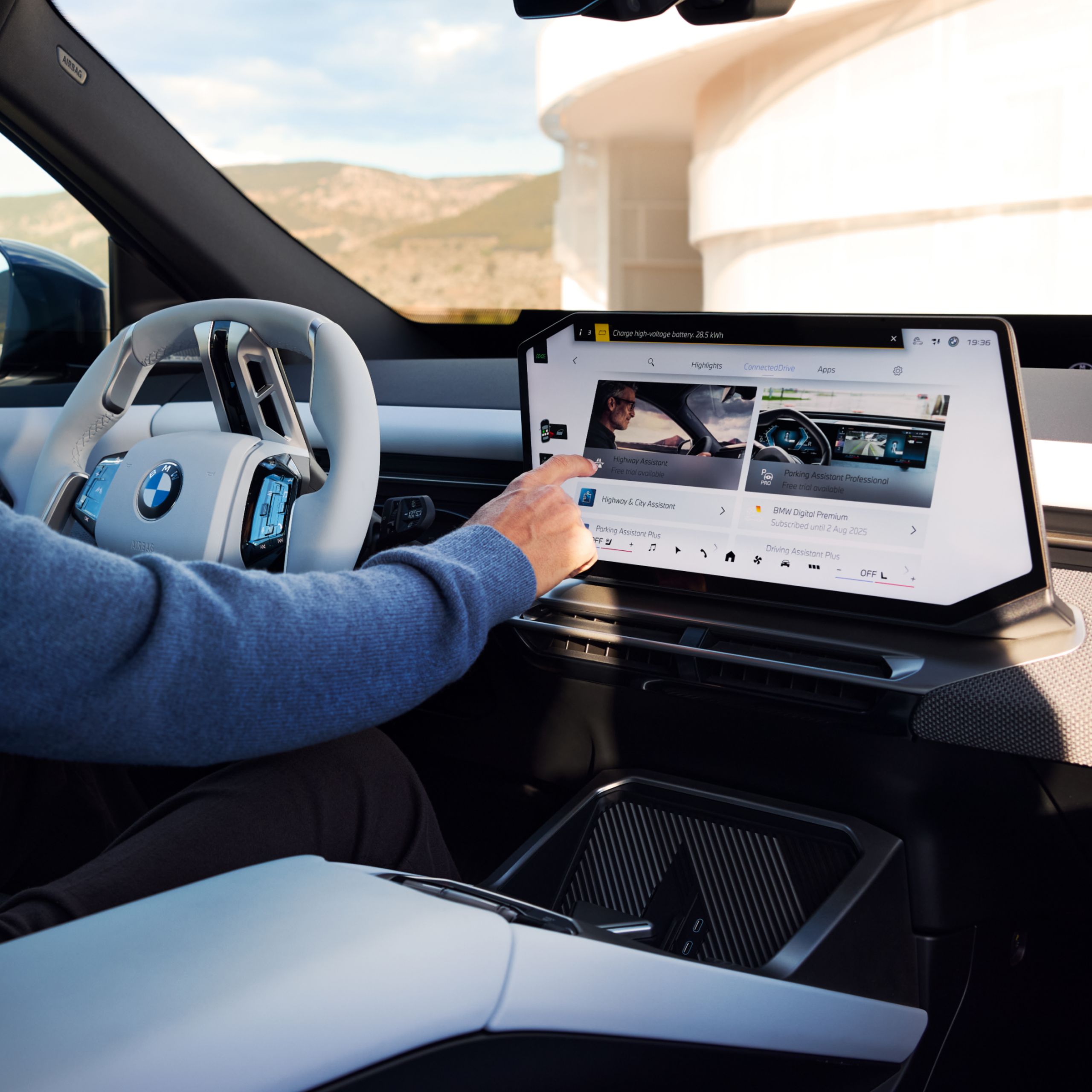 A person is using the touch display in a BMW to select an app