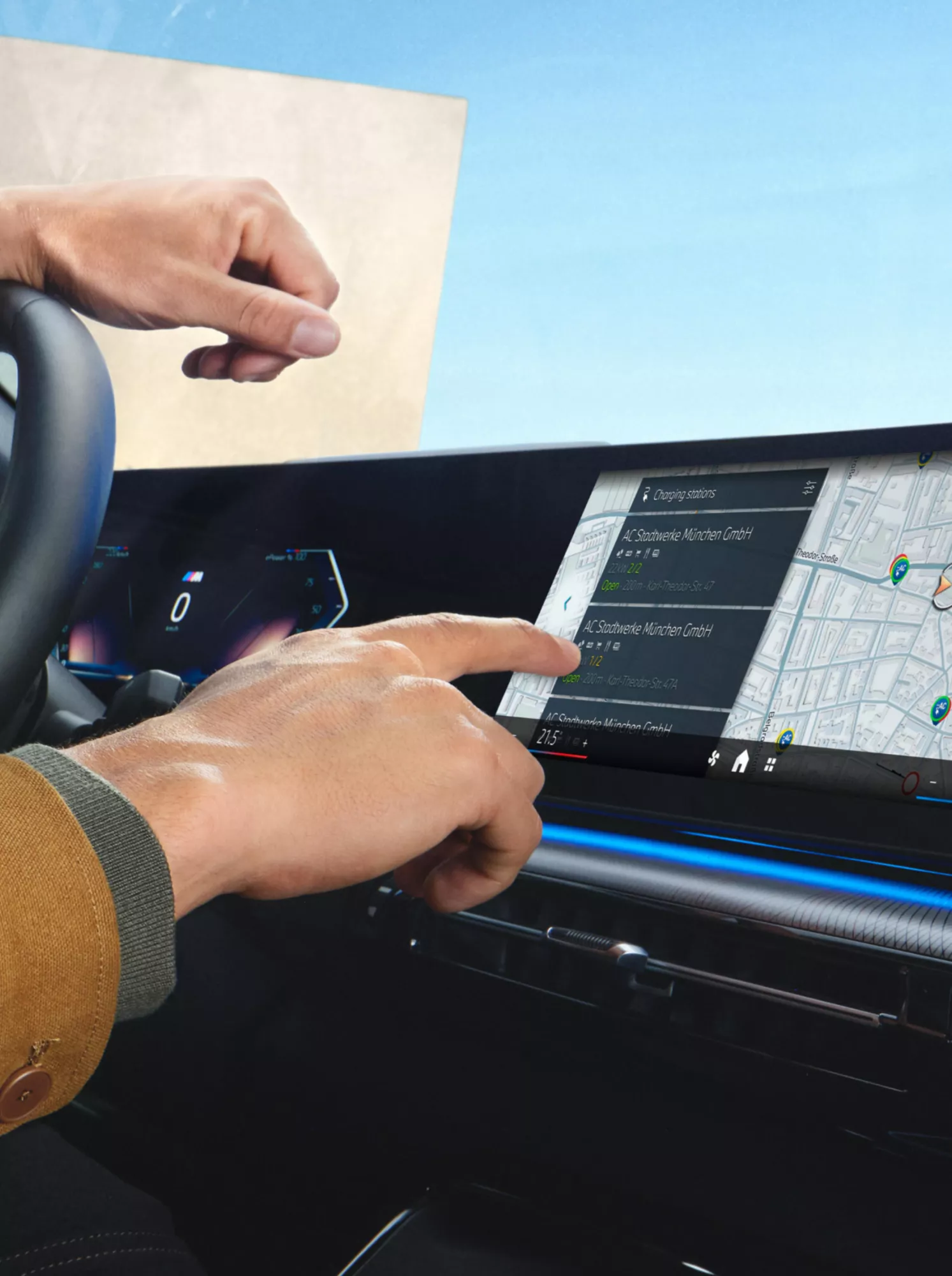 A person is operating the central display of a BMW to select charging stops along the route on the map