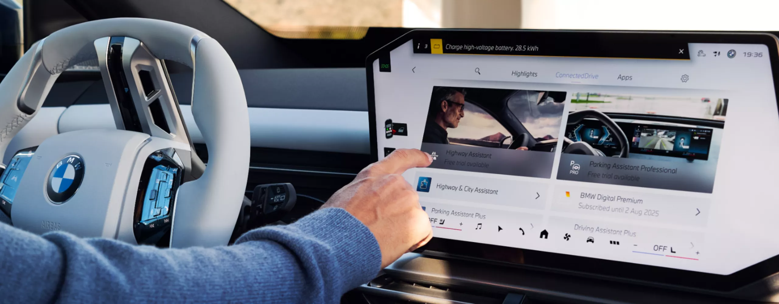 A person is operating the central display that displayed various bookable offers of the ConnectedDrive Store
