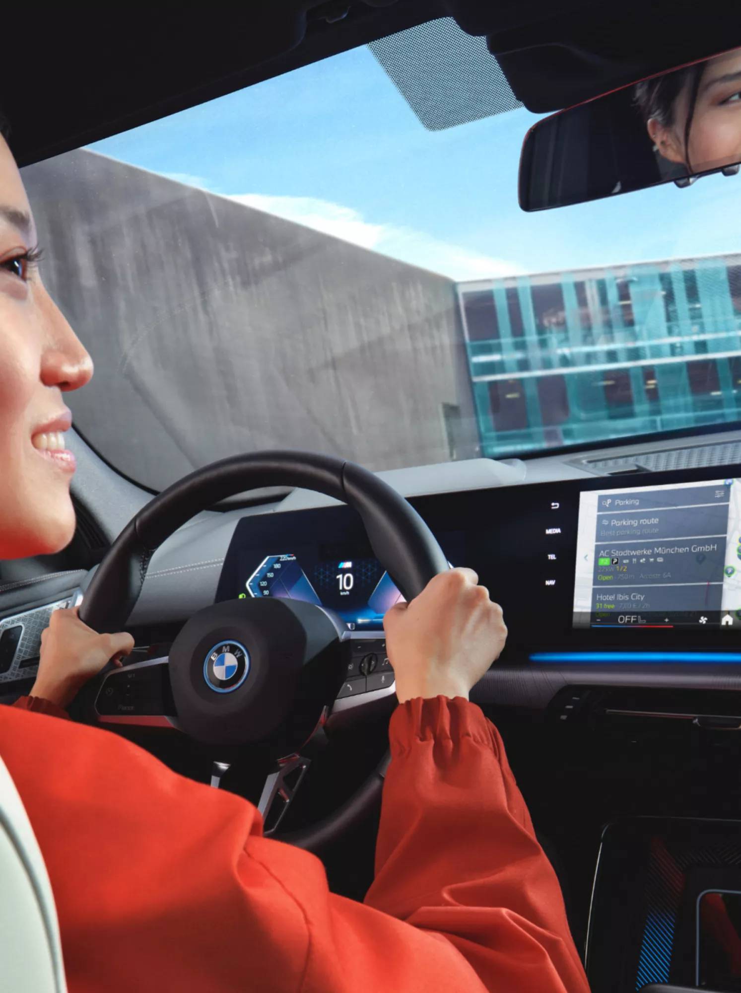 A woman is looking into the rear view mirror while parking