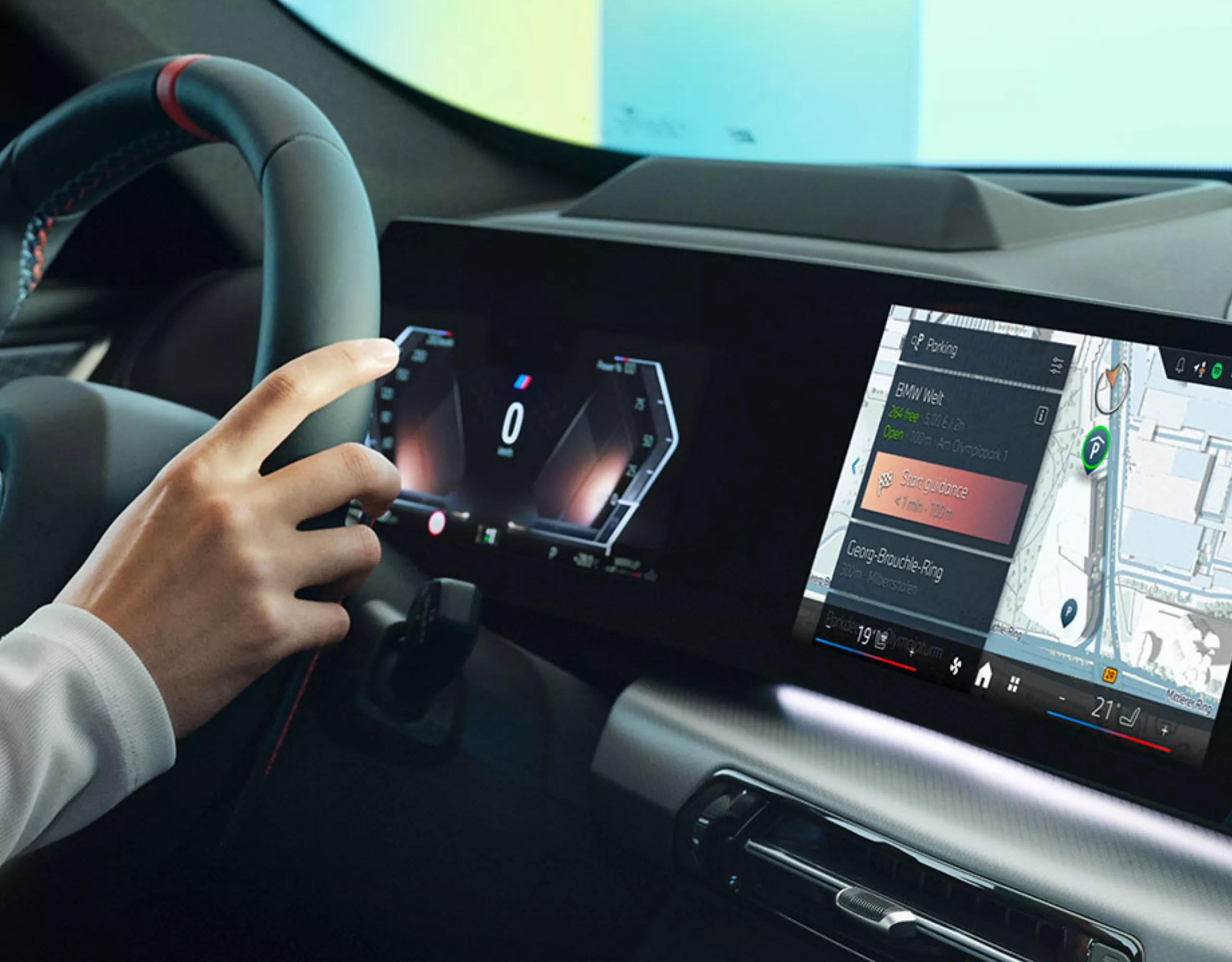 Side view of the BMW cockpit with a person at the steering wheel and BMW Maps navigation displayed on the Curved Display