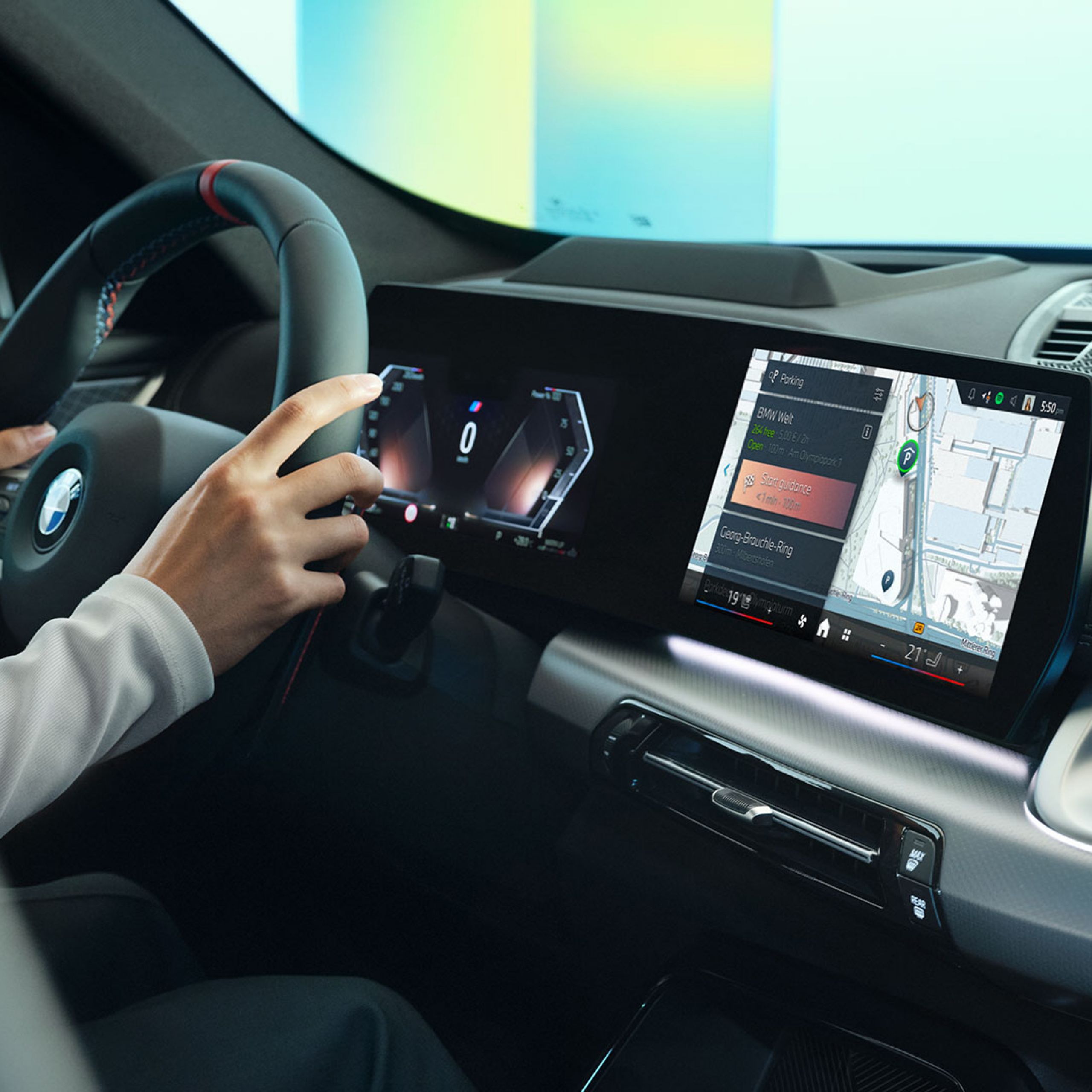 Side view of the BMW cockpit with a person at the steering wheel and BMW Maps navigation displayed on the Curved Display