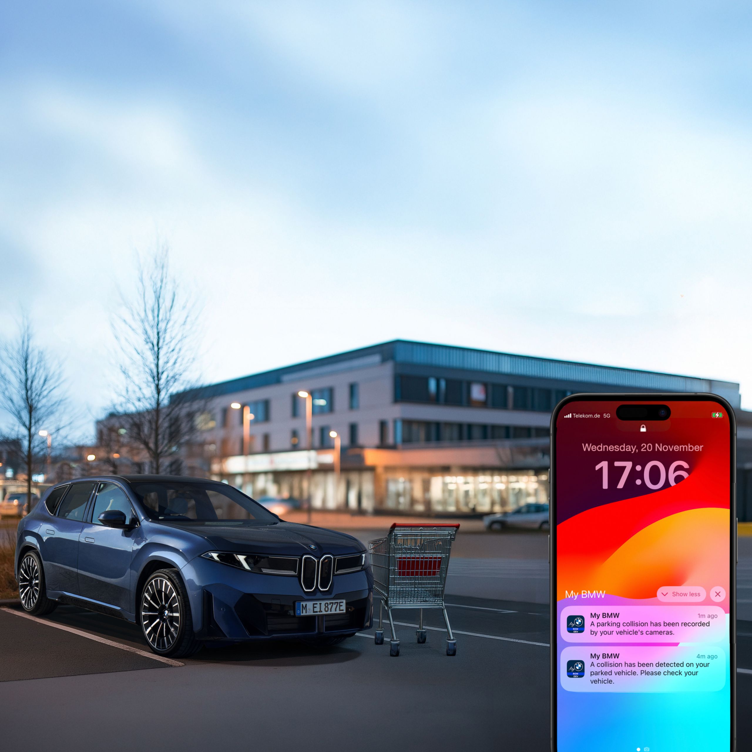 Smartphone with My BMW notification of parking collision. In the background, a parked BMW represent the collision with a shopping cart