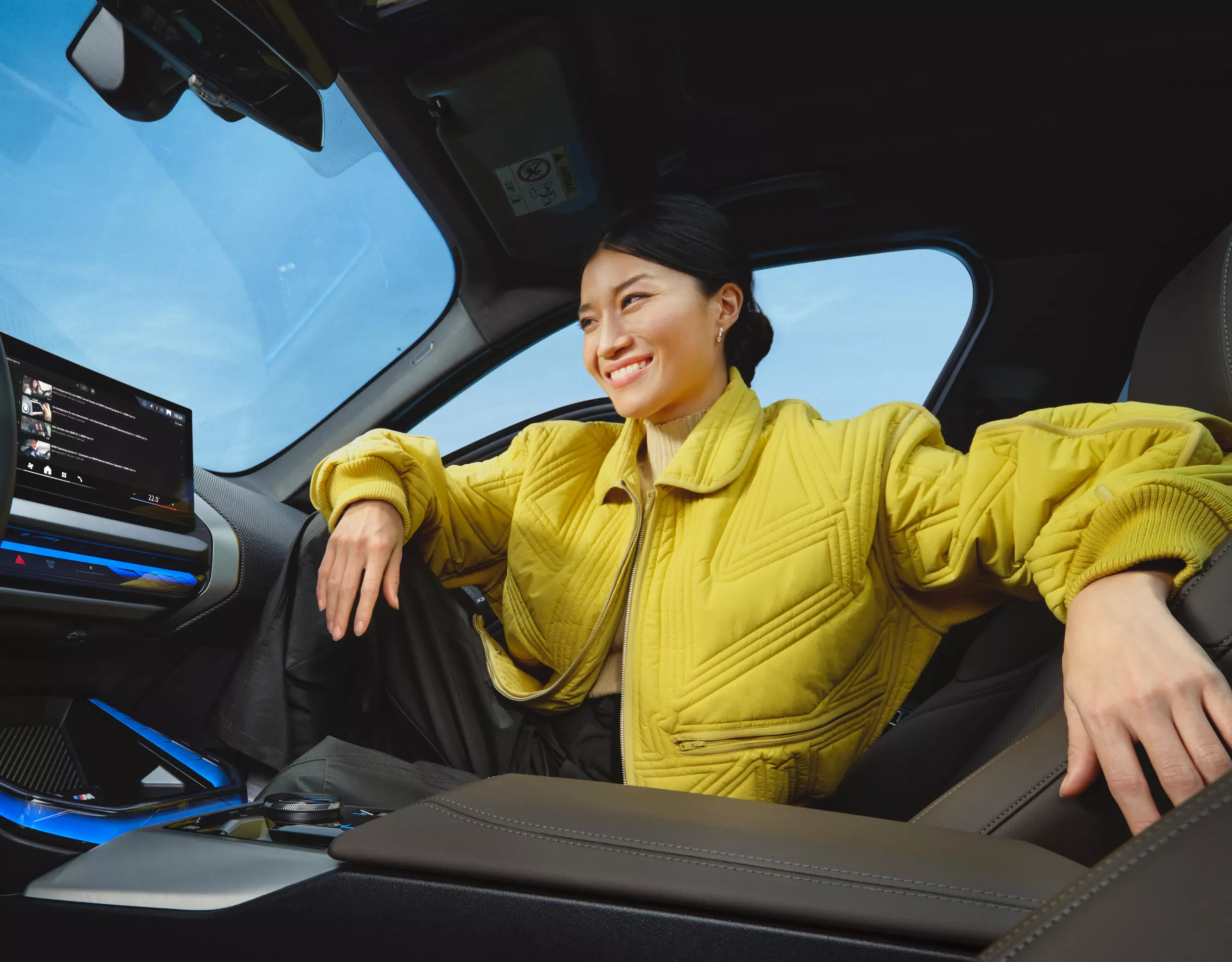 Frau sitzt auf dem Beifahrersitz und blickt gut unterhalten auf das zentrale Display
